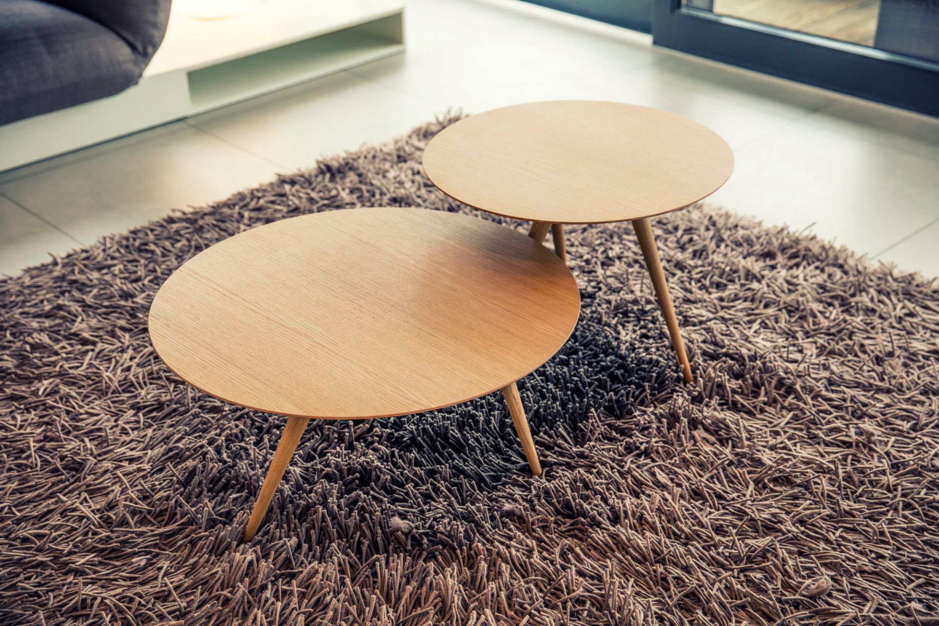 Zwei Turn Beistelltische von Maigrau, Esche weiß, auf einem braunen Teppich im Wohnzimmer.