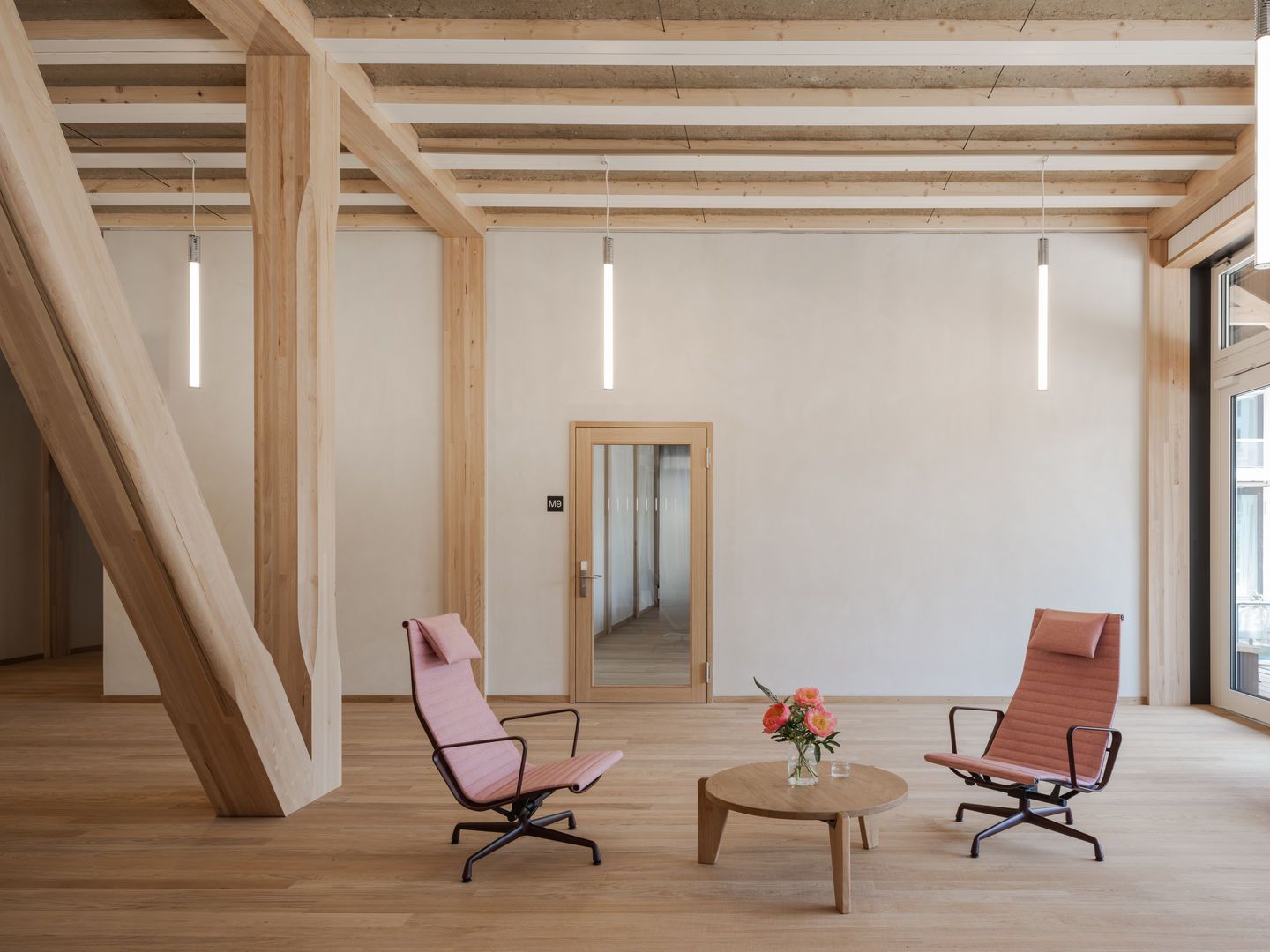 Zwei Aluminium Chair EA 125 Sessel von Vitra in einem hellen, modernen Raum mit Holzboden.