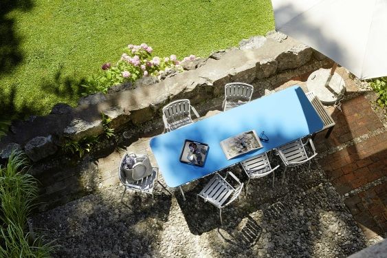 Draufsicht: Blauer Haefeli Esstisch Outdoor mit Stühlen im Garten, ideal für Mahlzeiten im Freien.