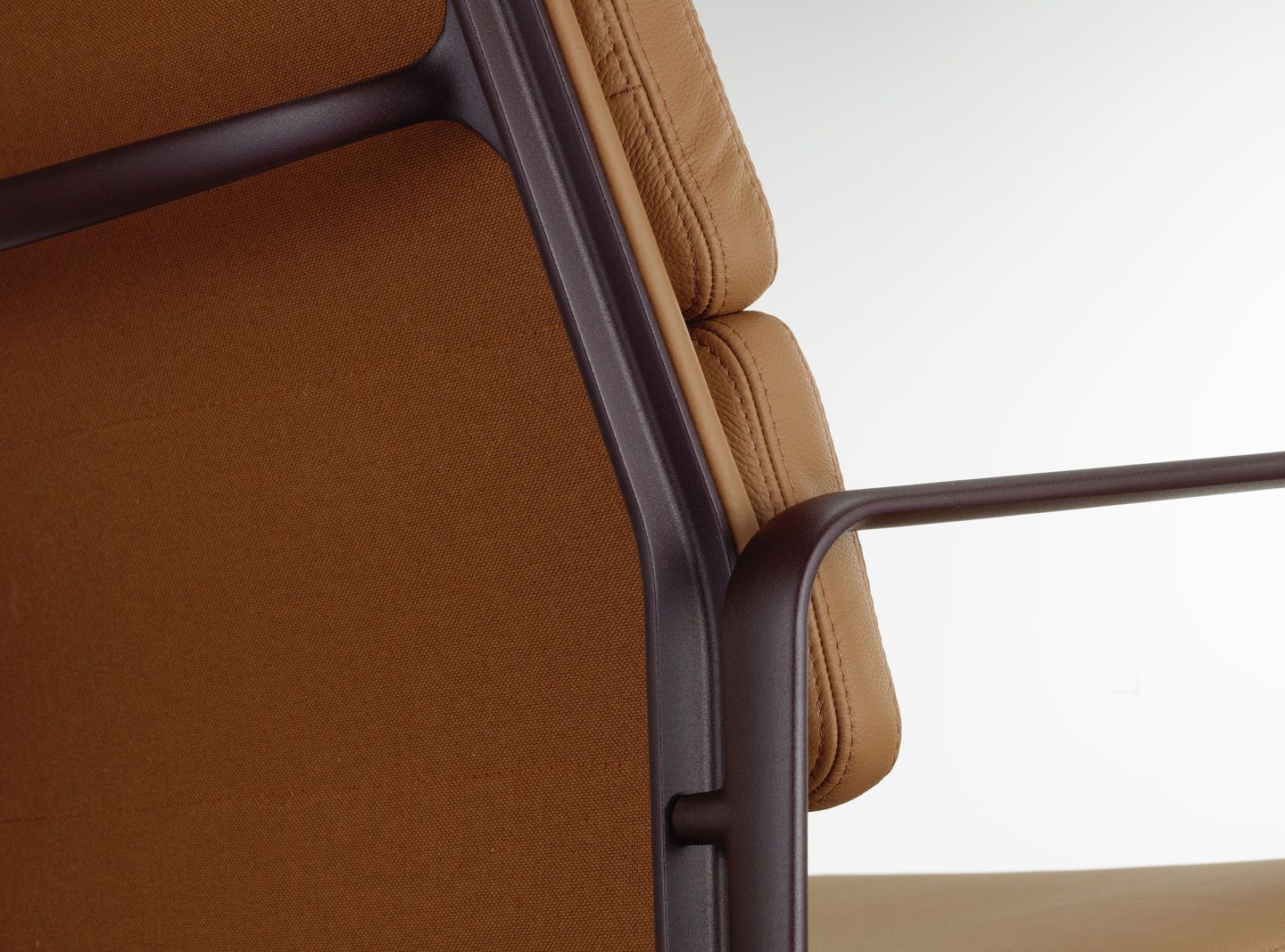 Detailaufnahme des Vitra Soft Pad Chair EA219 mit braunem Leder und Textilbezug, Designklassiker für Büro und Wohnbereich.