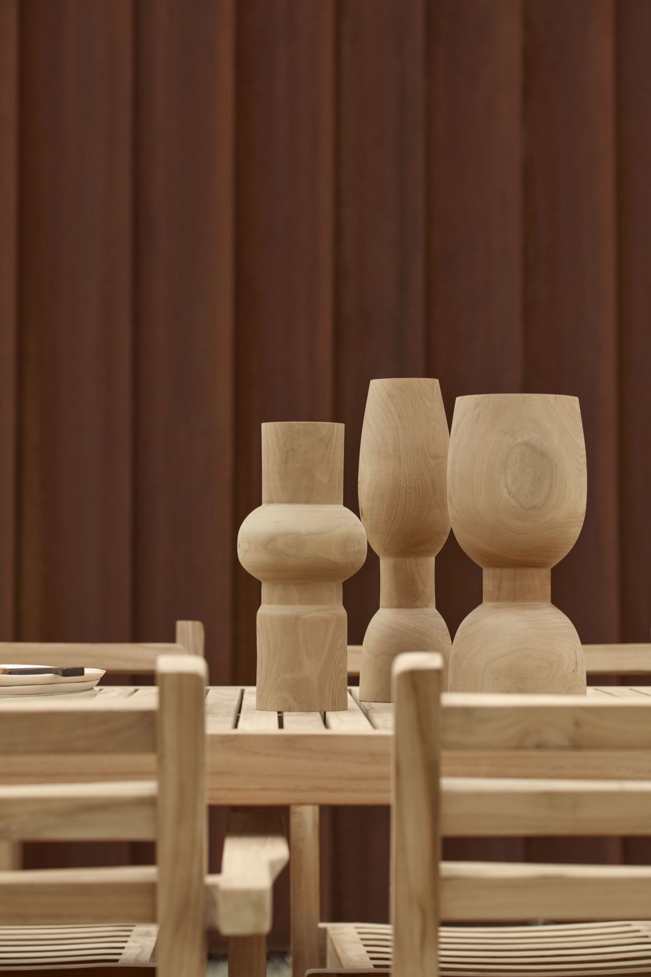 AH902 Carl Hansen Esstisch Outdoor aus Teakholz mit passenden Holzstühlen und Dekoration.