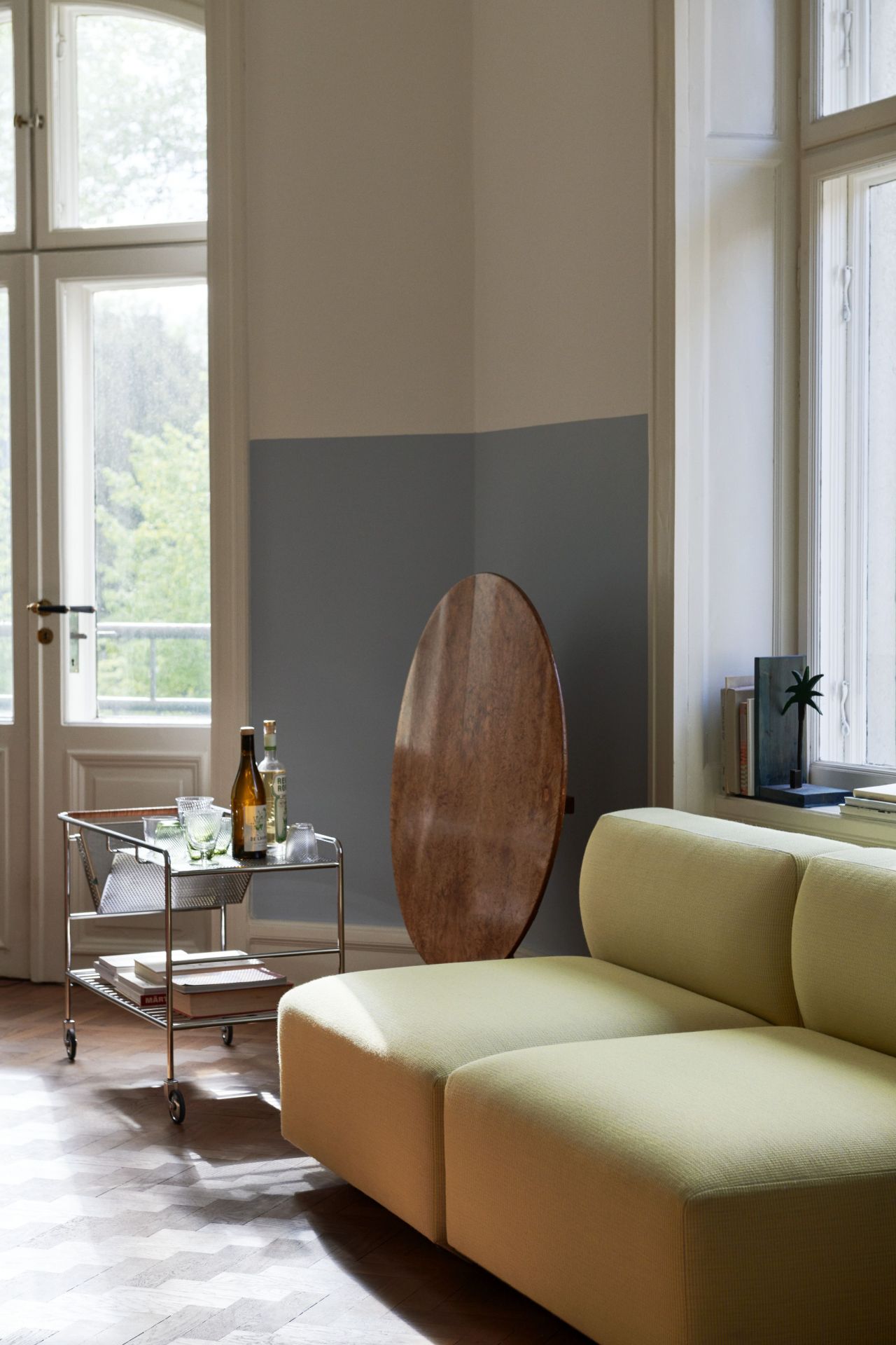 Alima NDS1 Rollwagen von AndTradition im Wohnzimmer mit Getränken und Gläsern neben einem Sofa.