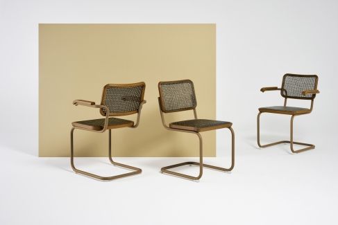Drei S 64 Freischwinger Stühle von Thonet mit Stahlrohrgestell und Wiener Geflecht auf weißem Hintergrund.