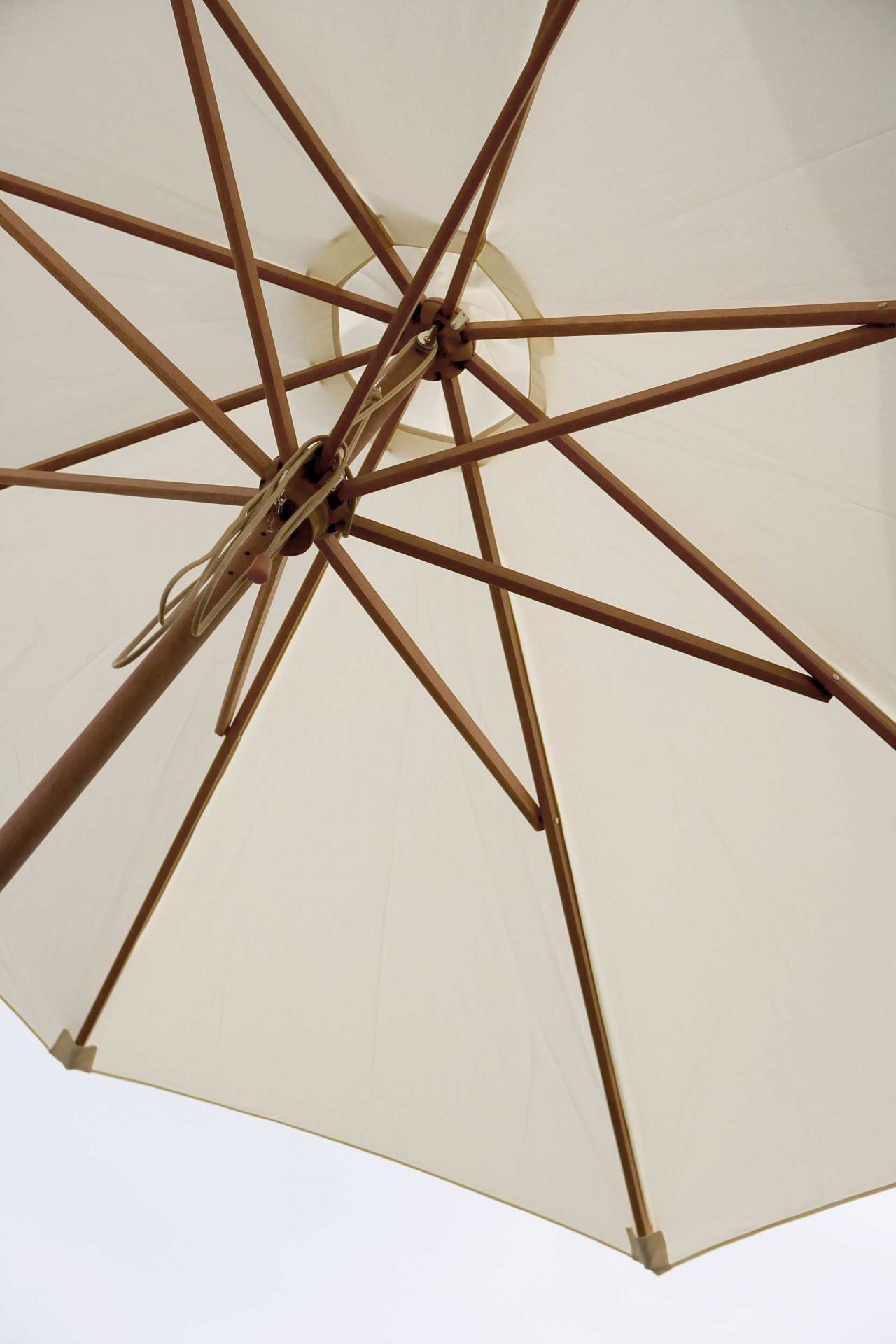 Detailaufnahme des Messina Sonnenschirms von Skagerak in Off White, zeigt Holzstreben und Stoff von unten.