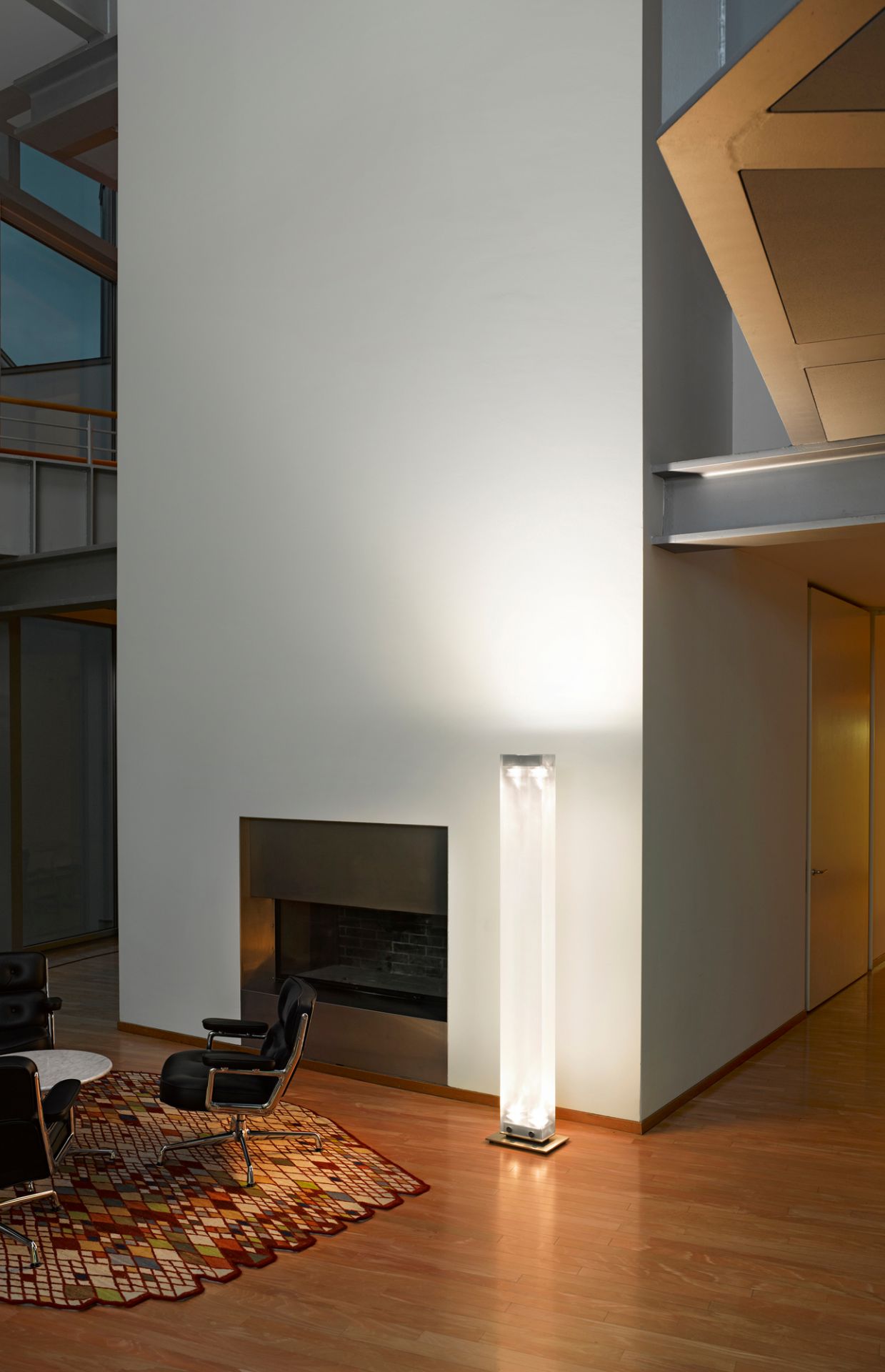 Moderne Twilight LED Stehleuchte von Belux im Wohnzimmer neben Kamin und Designermöbeln.