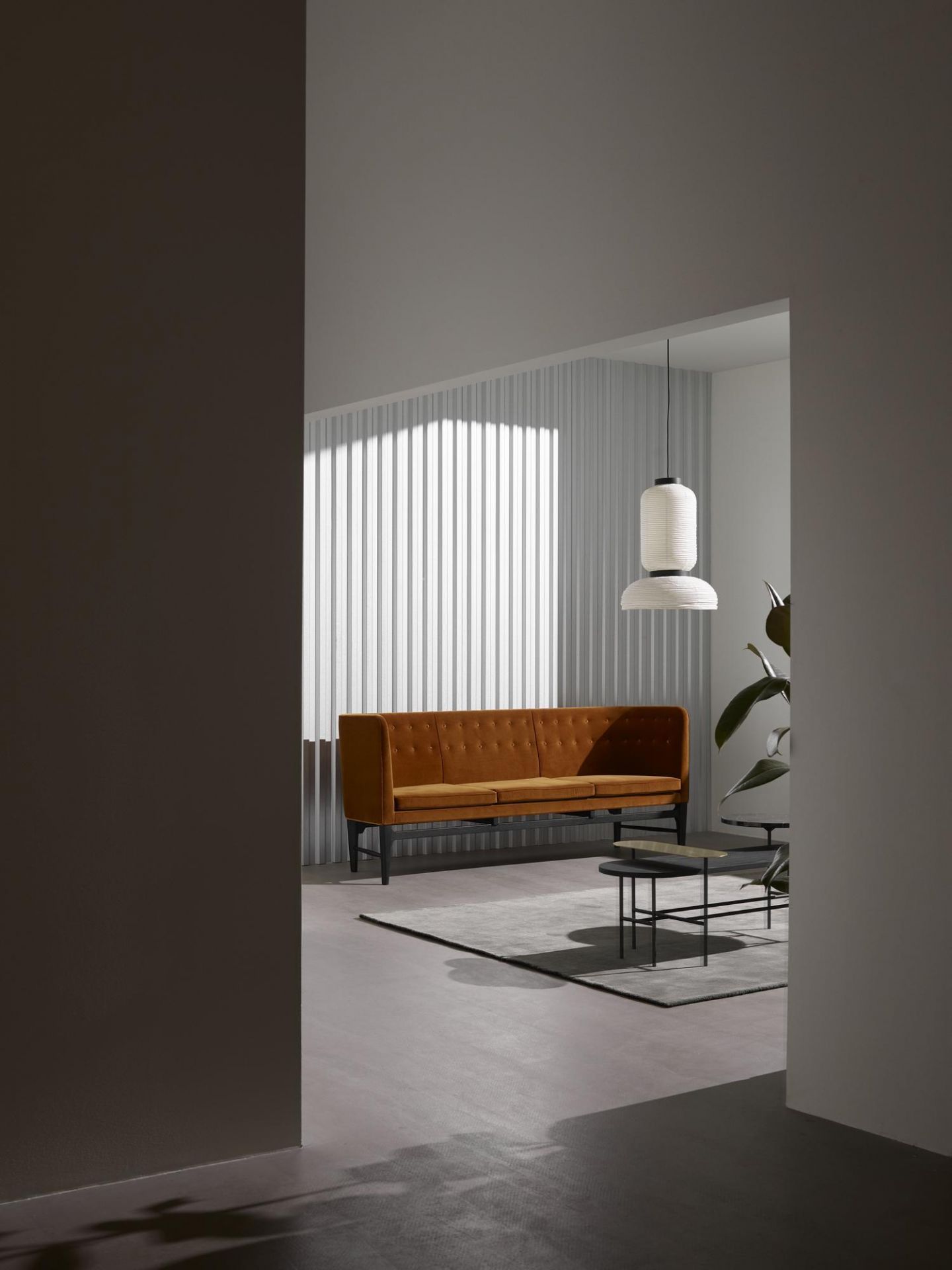 AndTradition Palette Table JH7 Couchtisch in Wohnraum-Szene mit Sofa, Lampe und Teppich.