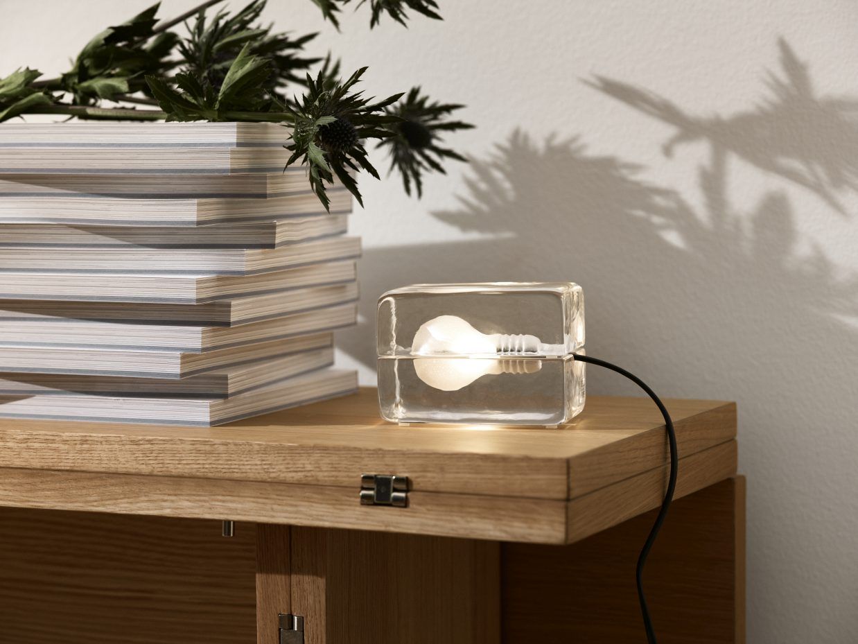 Block Lamp Mini LED Tischleuchte von Design House Stockholm auf einem Holztisch mit Dekoration.