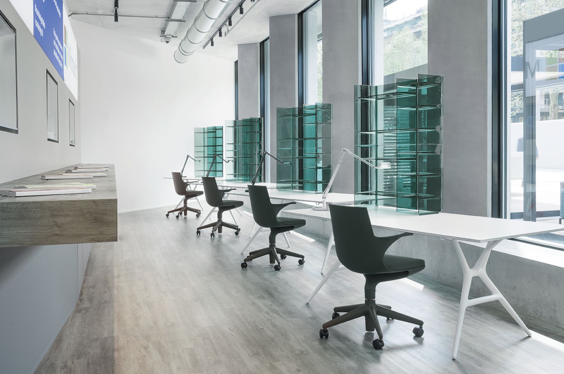 Schwarzer Spoon Chair Drehstuhl von Kartell in einem modernen Büro mit weißen Tischen.
