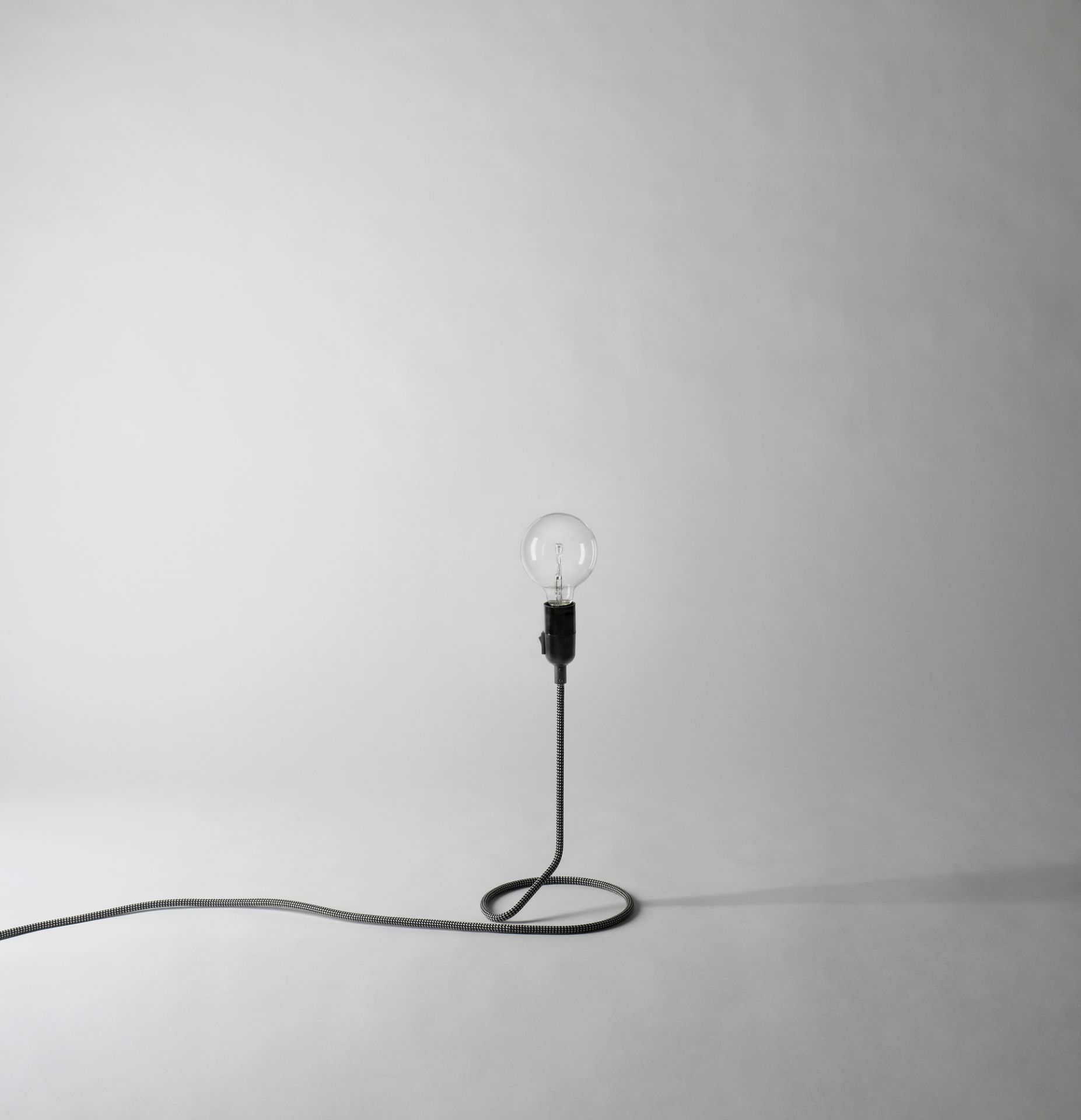 Cord Lamp Leuchte von Design House Stockholm: Minimalistische Tischleuchte mit dekorativem Textilkabel und Glühbirne.