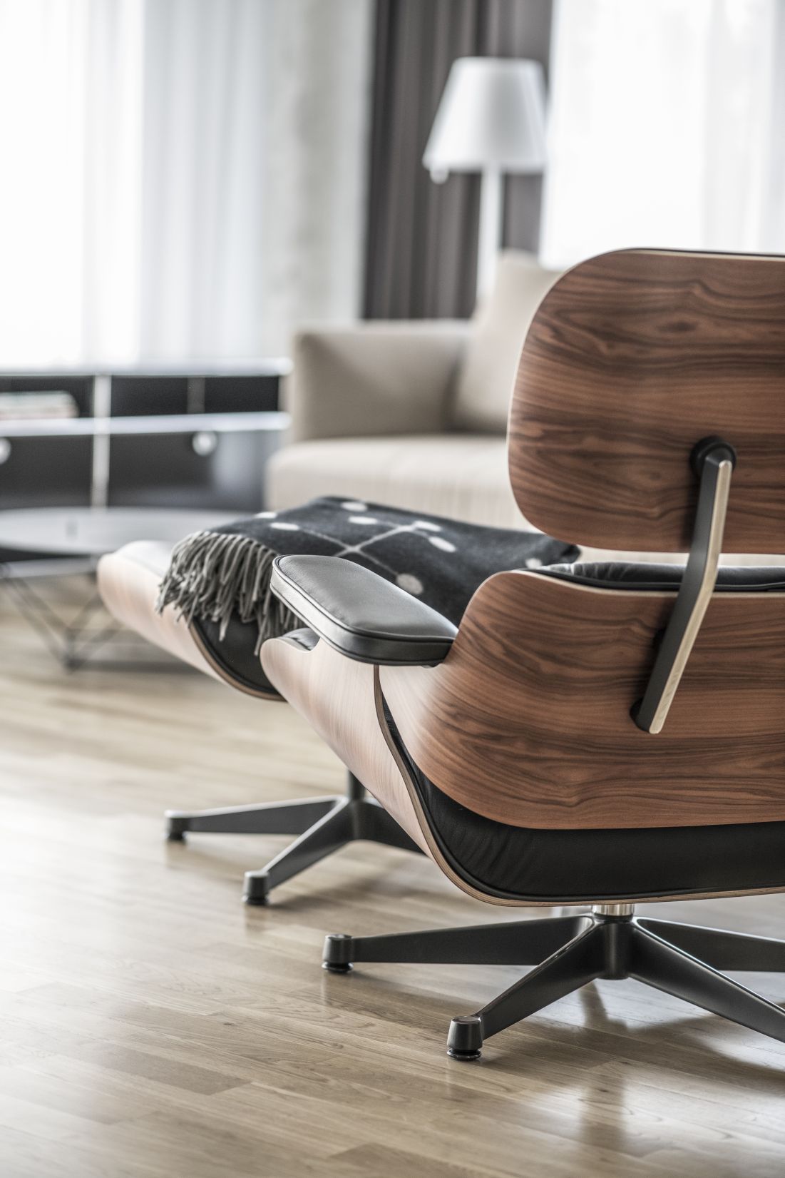Detailaufnahme eines Vitra Eames Lounge Chairs aus Holz und Leder mit Decke.