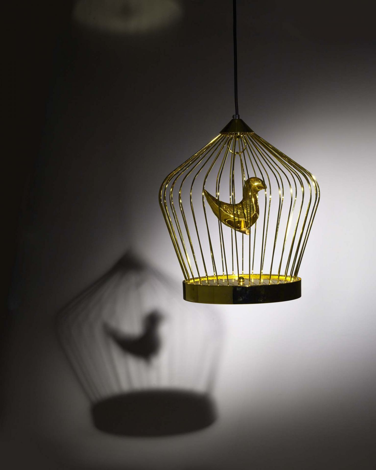 Goldene Twee T. Hängeleuchte von Casamania Horm mit Vogel im Käfig und Schattenwurf.