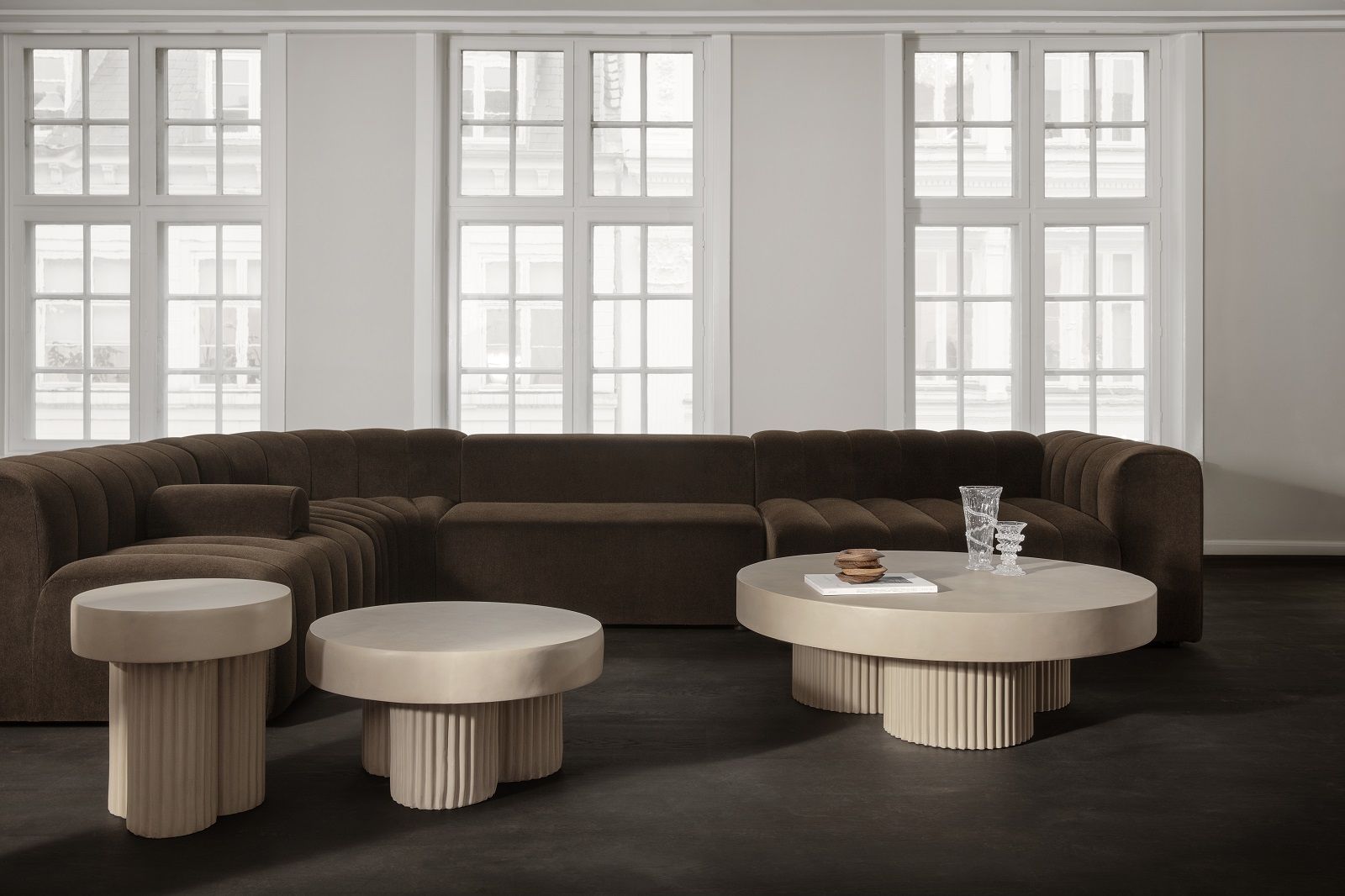 Norr11 Gear Beistelltisch und Couchtisch im Wohnzimmer mit braunem Sofa und minimalistischer Dekoration.