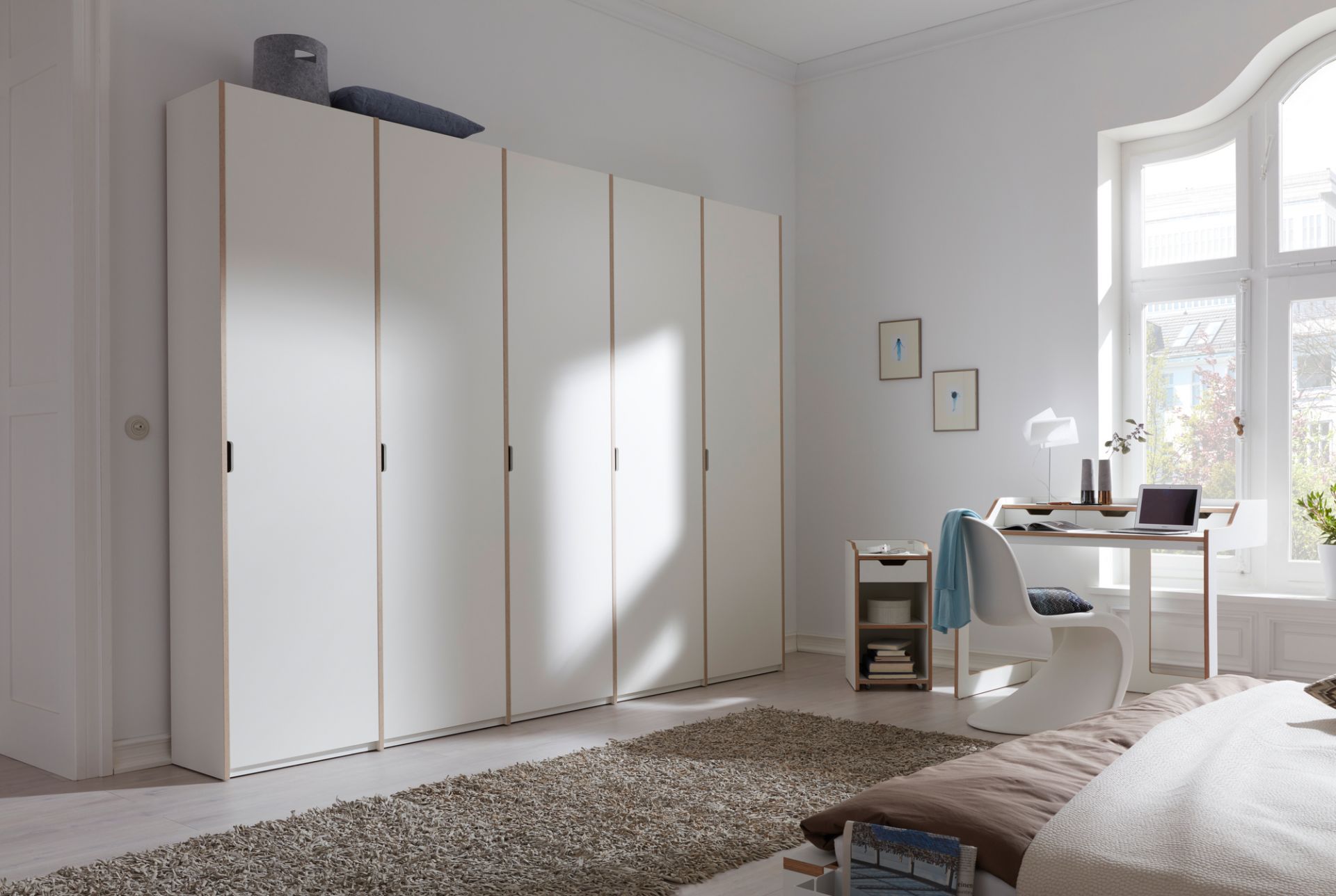 Helles Schlafzimmer mit großem, weißen Plane Sekretär von Müller Möbelwerkstätten und passendem Schreibtisch.