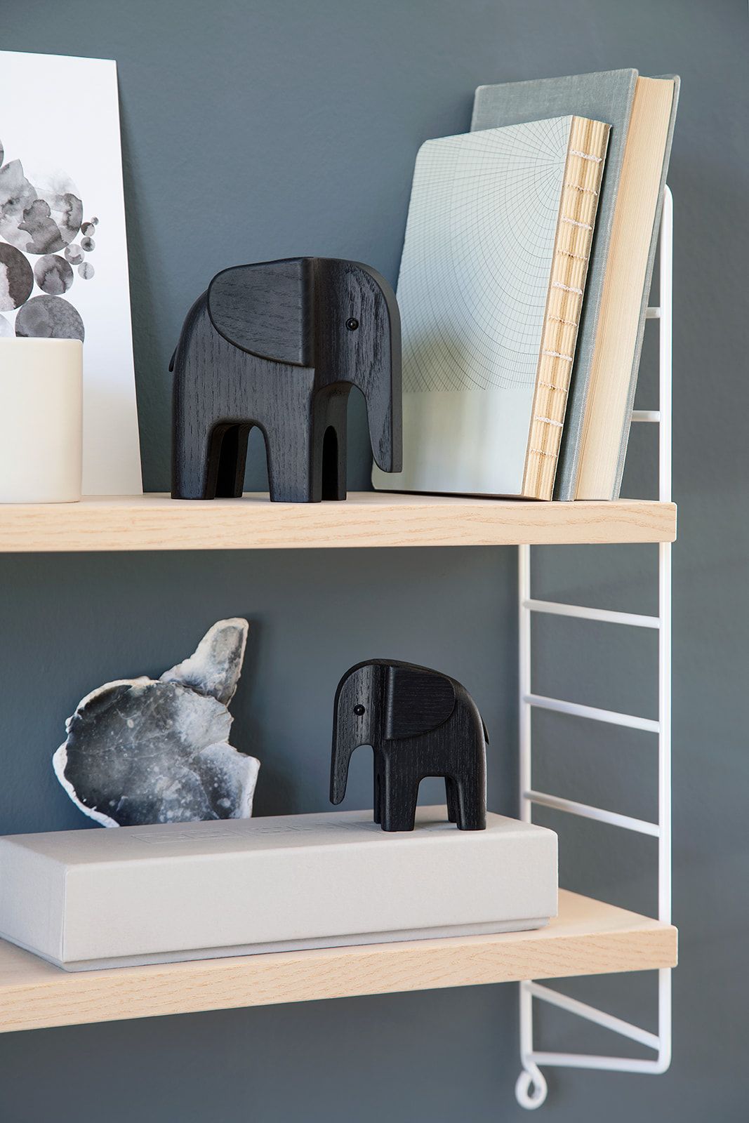 Zwei schwarze Baby Elefanten von Novoform aus Holz auf einem Regal. Dekorative Holzfiguren.