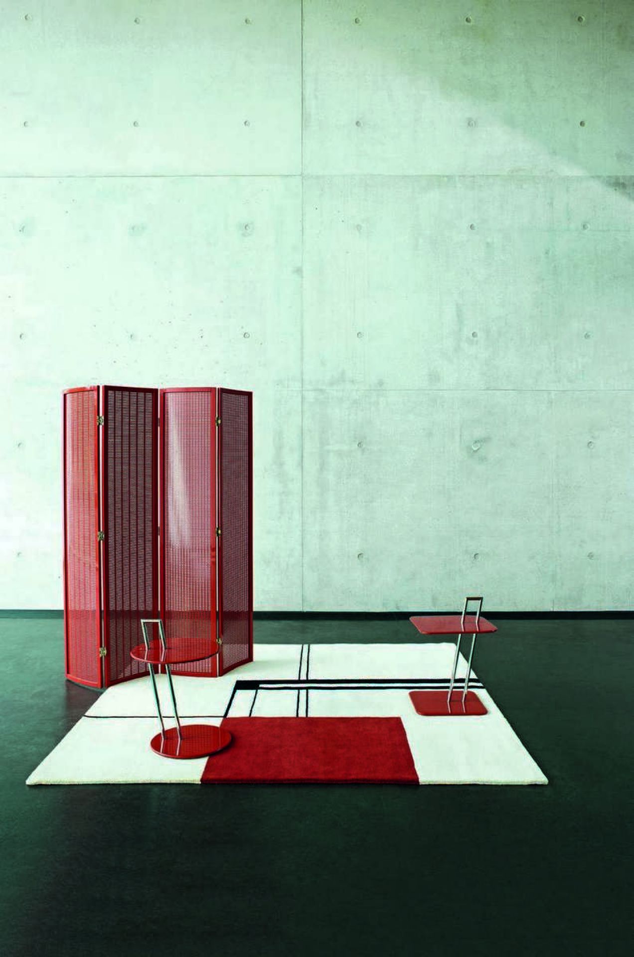 ClassiCon Beistelltisch Occasional Table in Rot mit Raumteiler und Teppich auf dunklem Boden.