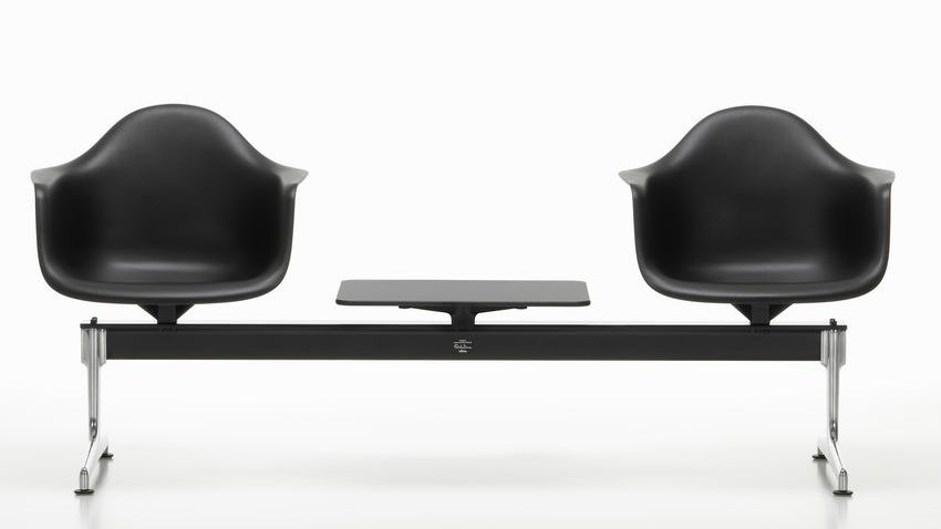 Schwarzer Eames Plastic Armchair auf Traverse von Vitra mit Tischplatte, modernes Design für Wartebereiche.