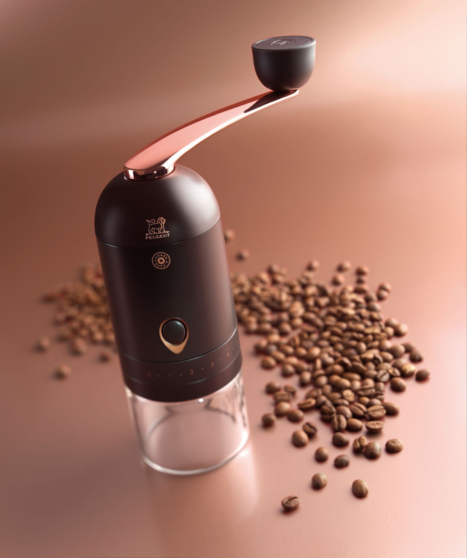 L'Arbre à Café Peugeot Kaffeemühle mit Handkurbel und Kaffeebohnen auf braunem Untergrund.