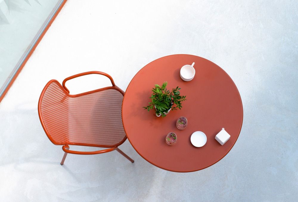Ronda X Stuhl von Emu, orangefarbener Outdoor-Stuhl aus Metallgeflecht mit passendem Tisch.