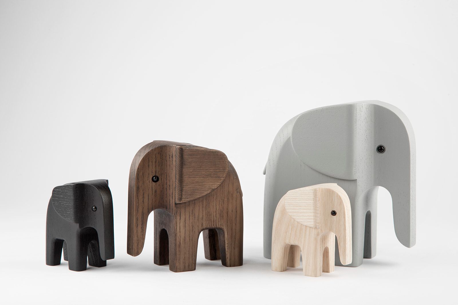 Vier Holz-Elefanten in Schwarz, Braun, Grau und Naturholz, Novoform Design. Dekorative Holzfiguren.