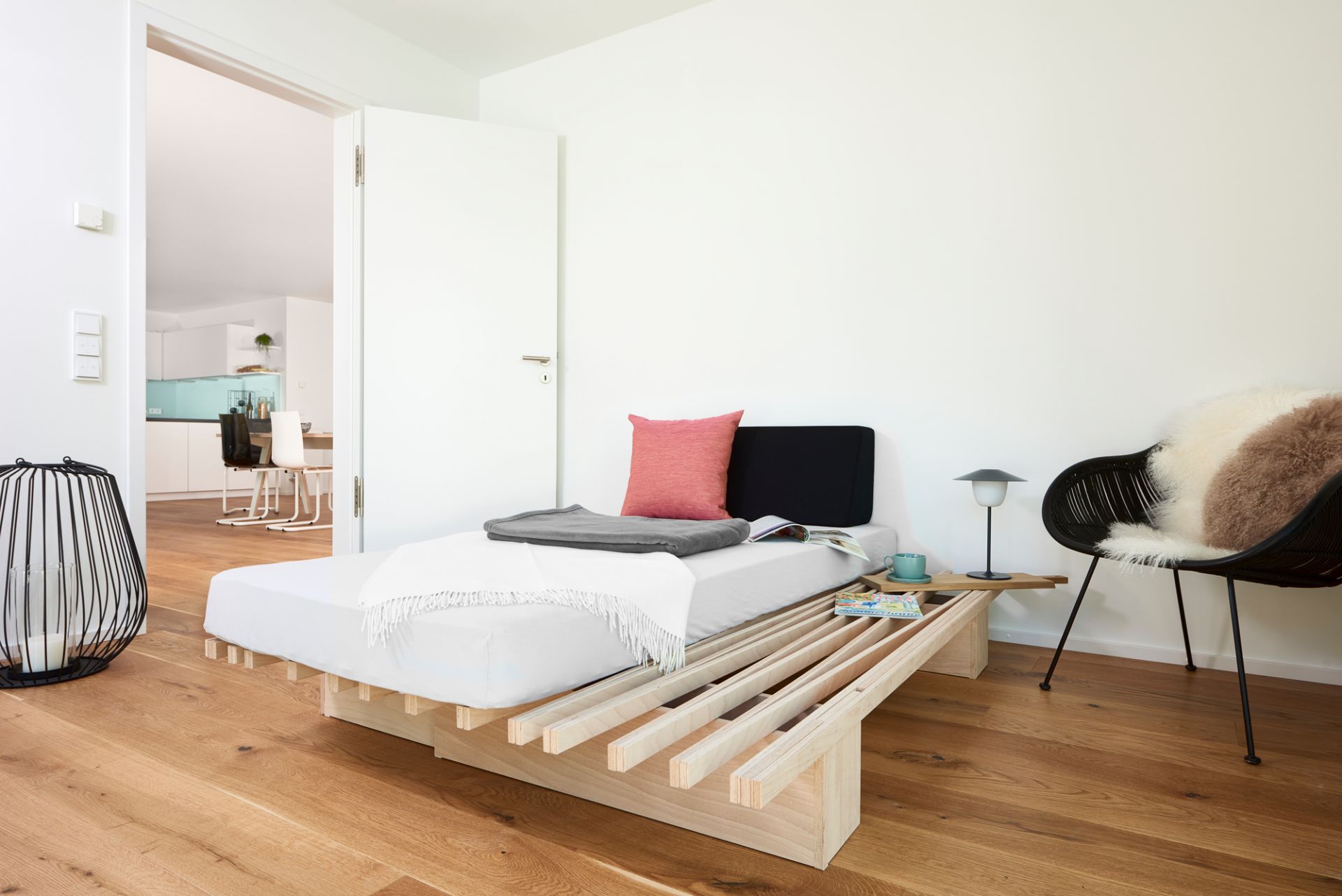 Tojo Faltmatratze Ergo im modernen Schlafzimmer, mit Kissen und Decke dekoriert. Ideal für Gäste.