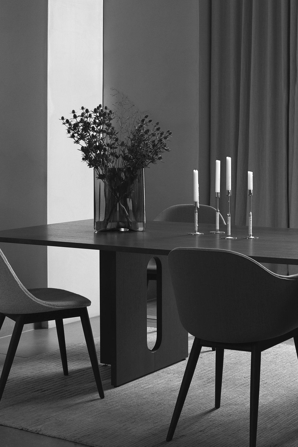 Schwarz-Weiß-Foto von Harbour Dining Chair Stühlen von Audo Copenhagen an einem Esstisch mit Kerzen und Dekoration.