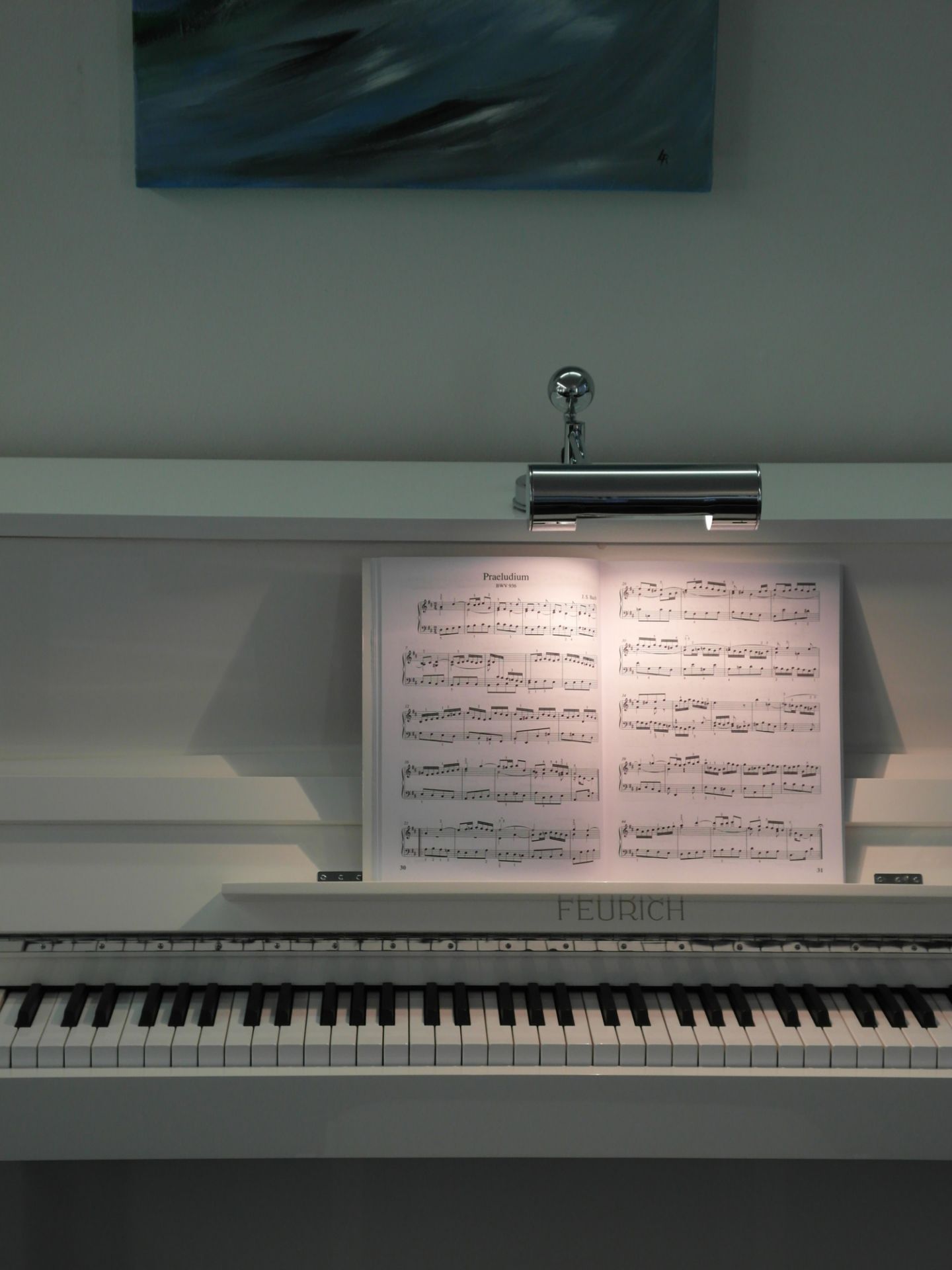 DS 28 Klavierleuchte von Tecnolumen auf weißem Klavier mit Notenblatt, perfekte Beleuchtung zum Musizieren.