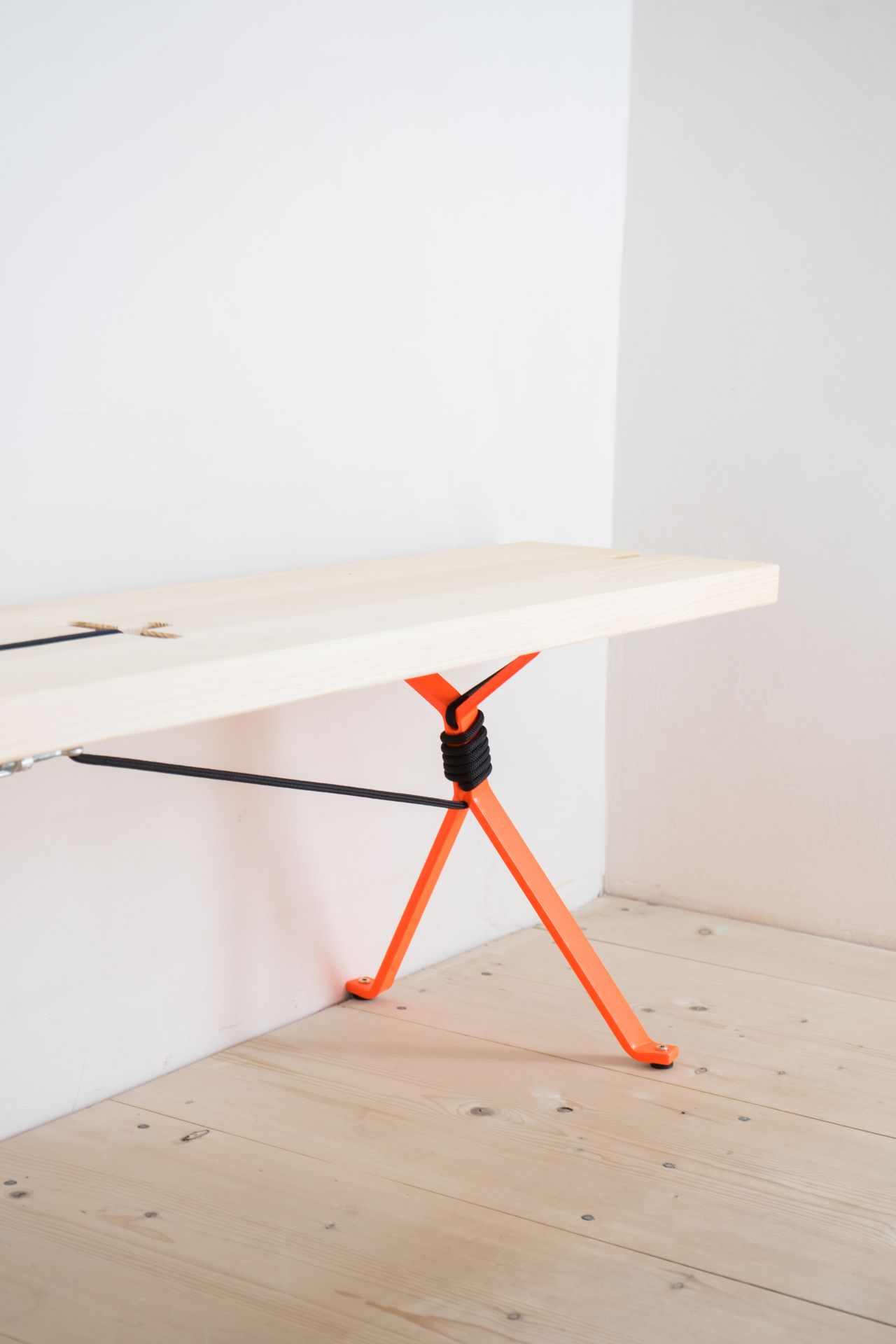 Nils Holger Moormann Kampenwand Bank aus hellem Holz mit auffälligem, orangefarbenem Gestell.