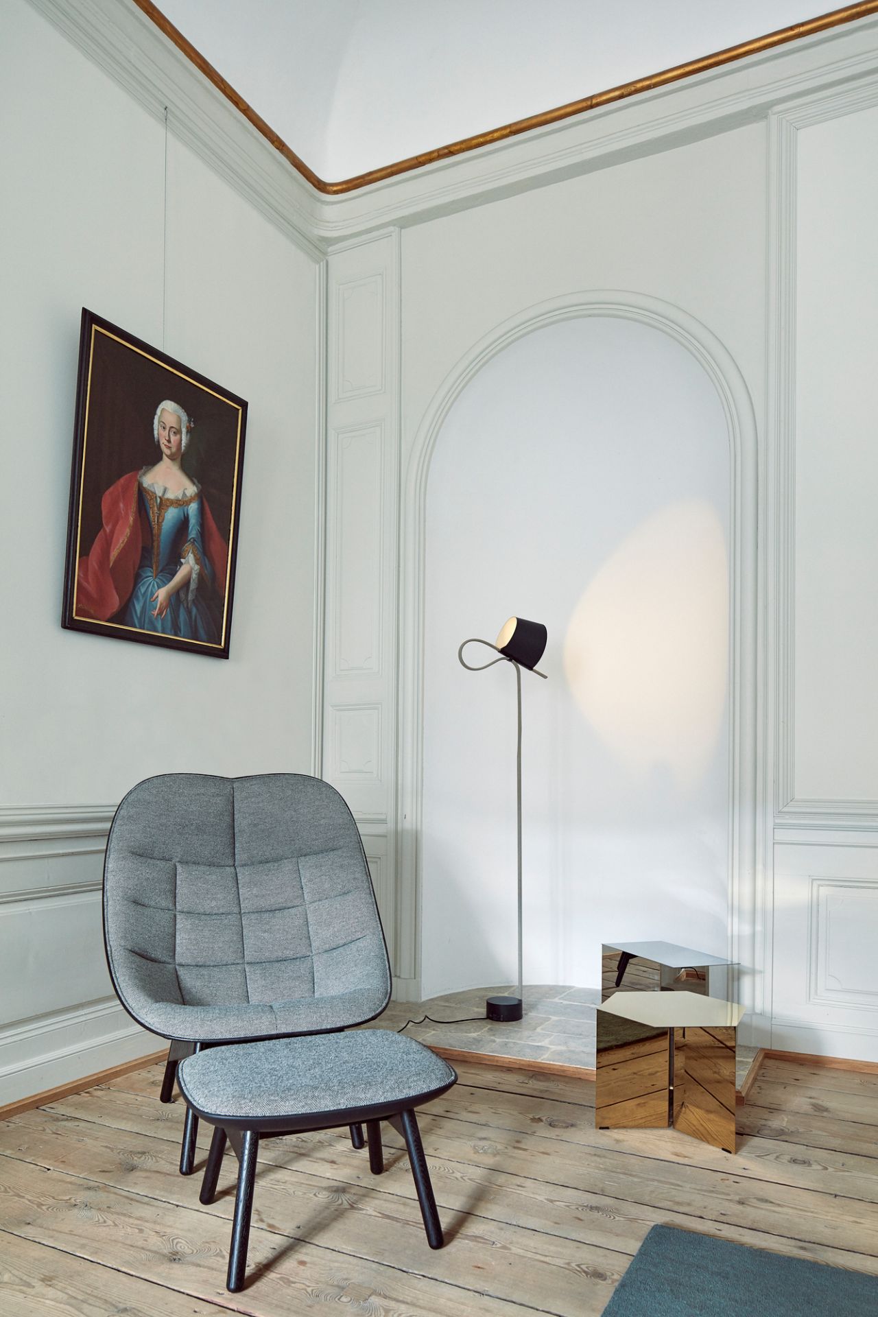 Grauer Uchiwa Quilt Sessel von Hay mit Fußhocker in stilvollem Interieur mit Lampe und Gemälde.