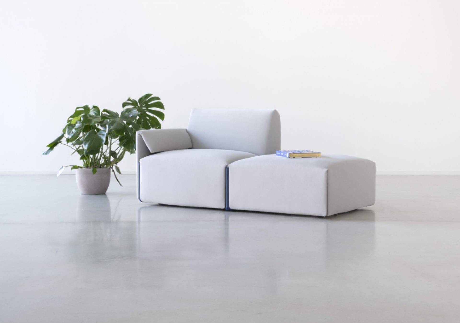 Costume Modulsofa mit Armlehne links, hellgrauer Kvadrat Stoff und blauen Akzenten, modernes Design.