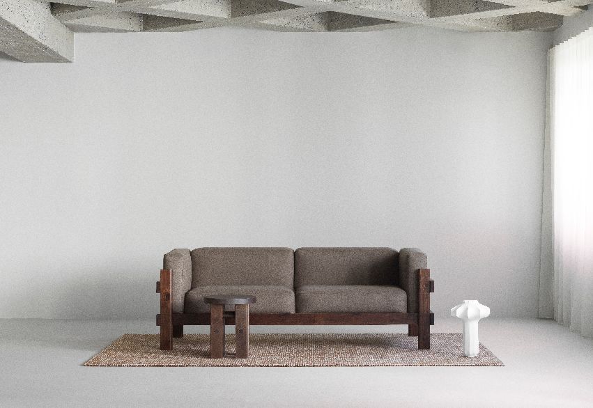 Normann Copenhagen Phantom Tischleuchte in Weiß neben Sofa und Beistelltisch auf Teppich.