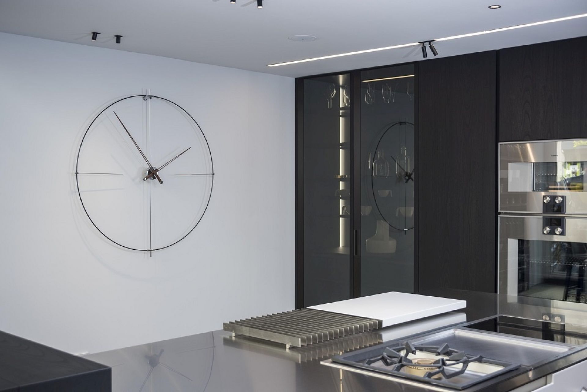 Weiße Nomon Wanduhr Bilbao N/L an einer Wand in einer modernen Küche.