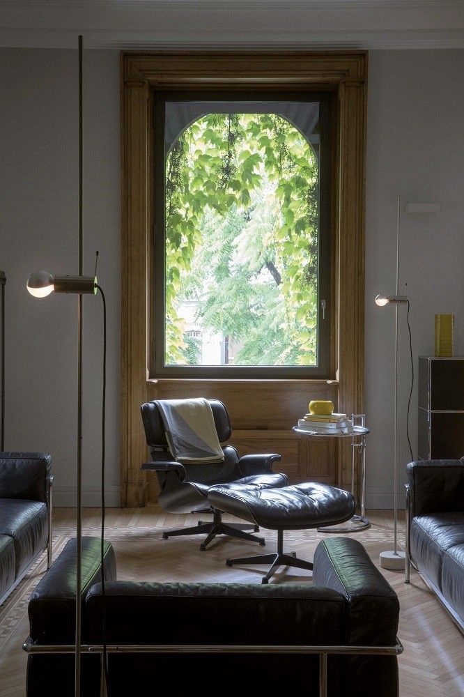 Agnoli Stehleuchte von Oluce in modernem Wohnzimmer mit Ledersofa und Sessel.