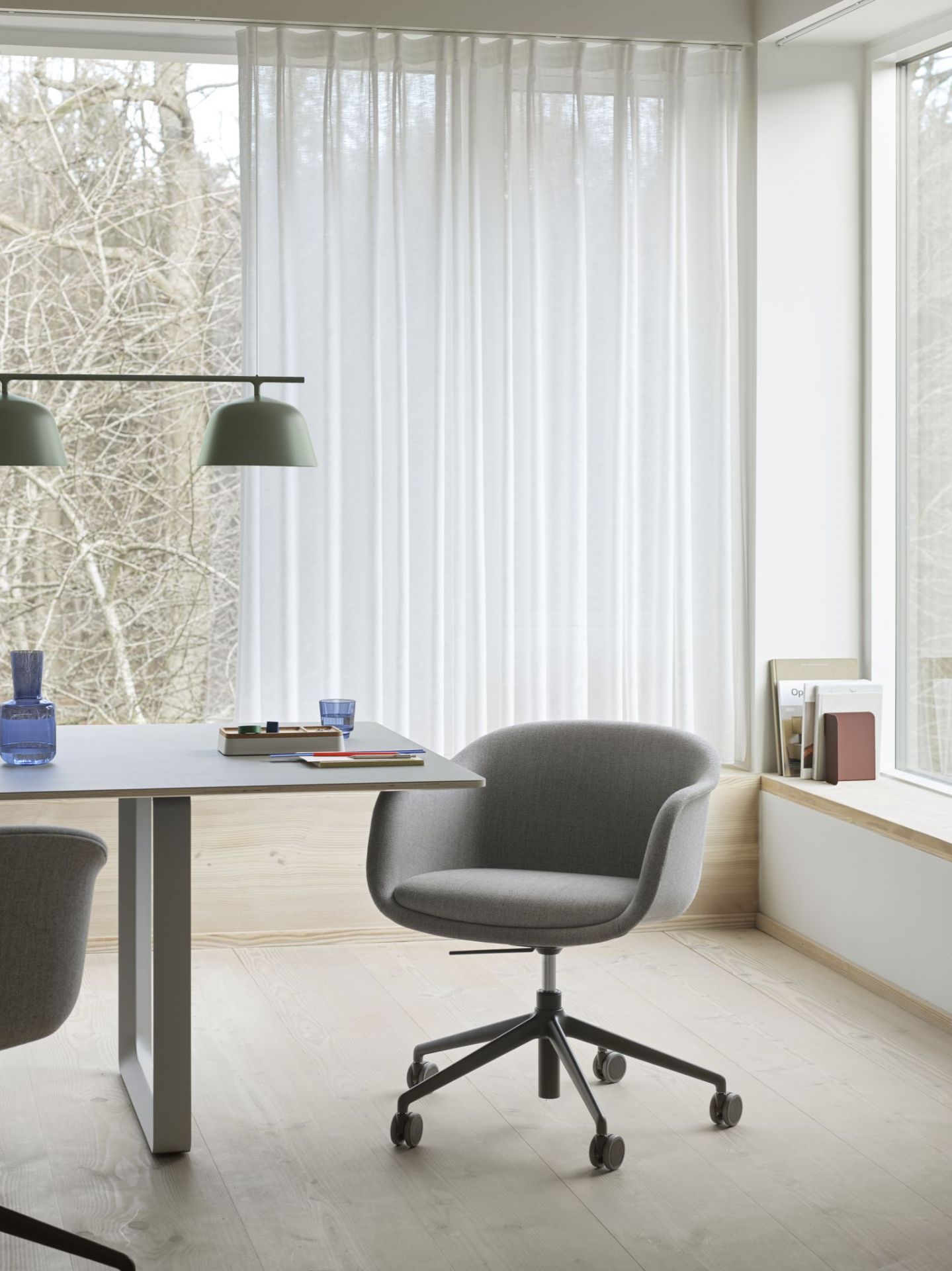 Grauer Fiber Conference Armchair von Muuto mit Drehgestell und Polsterung im modernen Büro.