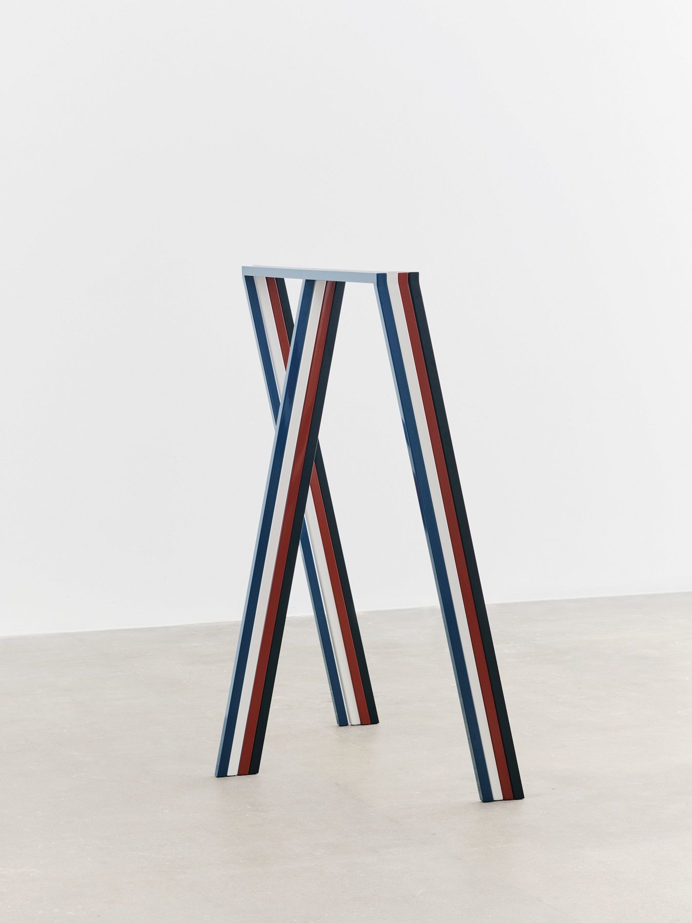Hay Loop Stand Wardrobe Garderobe mit blau, rot und weiß gestreiften Beinen vor weißem Hintergrund.