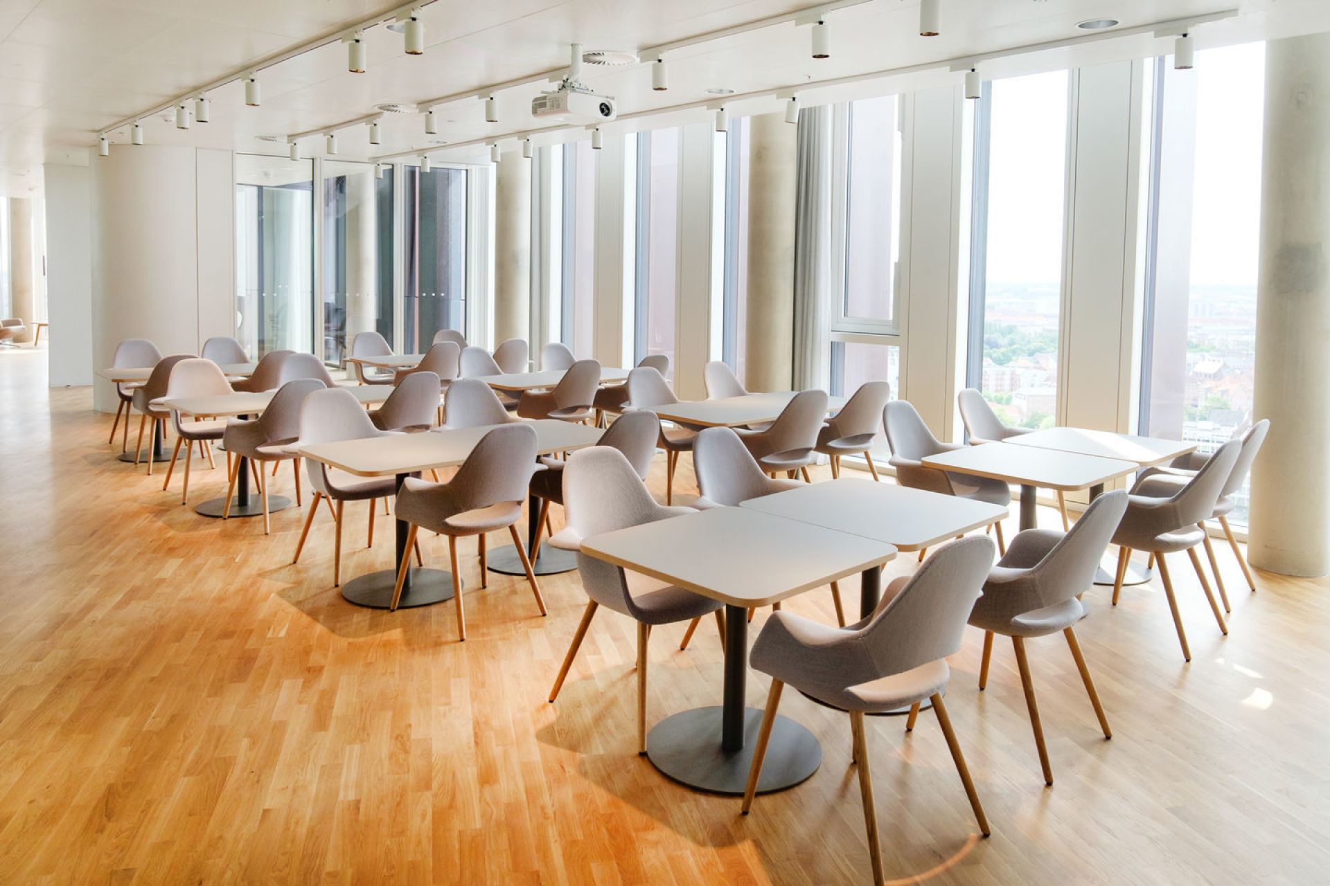 Helle Konferenzraumszene mit vielen Organic Conference Stühlen von Vitra und Tischen auf Parkettboden.