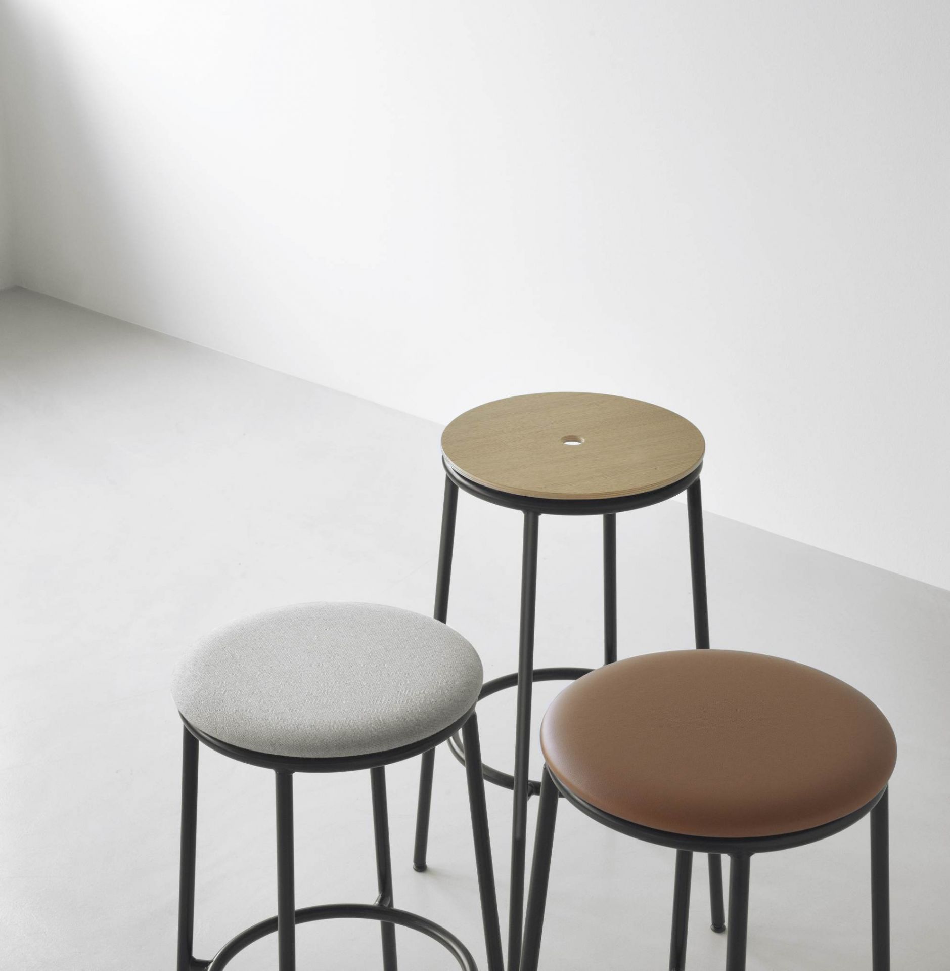 Drei Circa Barhocker von Normann Copenhagen in verschiedenen Ausführungen: Holz, Stoff und Leder.
