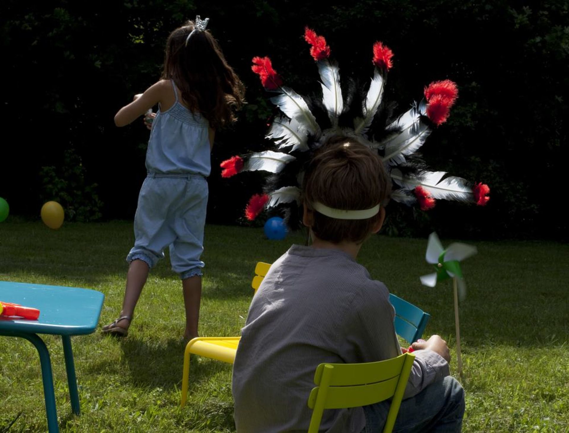 Kinder spielen im Garten mit Fermob Luxembourg Kinderstühlen und Tisch im Freien.