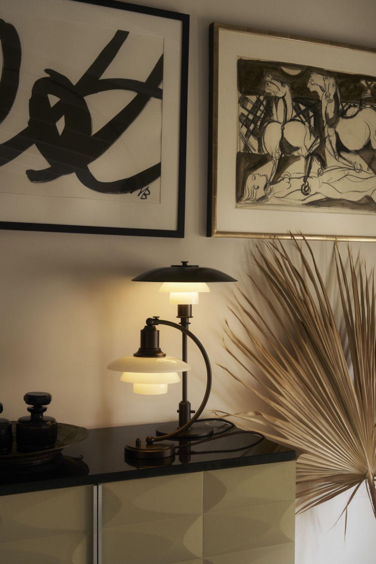 Nahaufnahme der PH 3/2 Aged Brass Tischleuchte von Louis Poulsen, warmes Licht, stilvolles Wohnaccessoire.