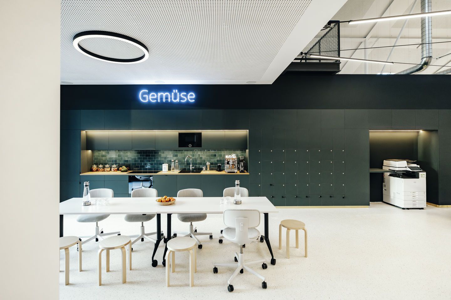 Vitra MedaMorph Klapptisch in modernem Büro mit Stühlen und Küchenzeile, ideal als Arbeitstisch.
