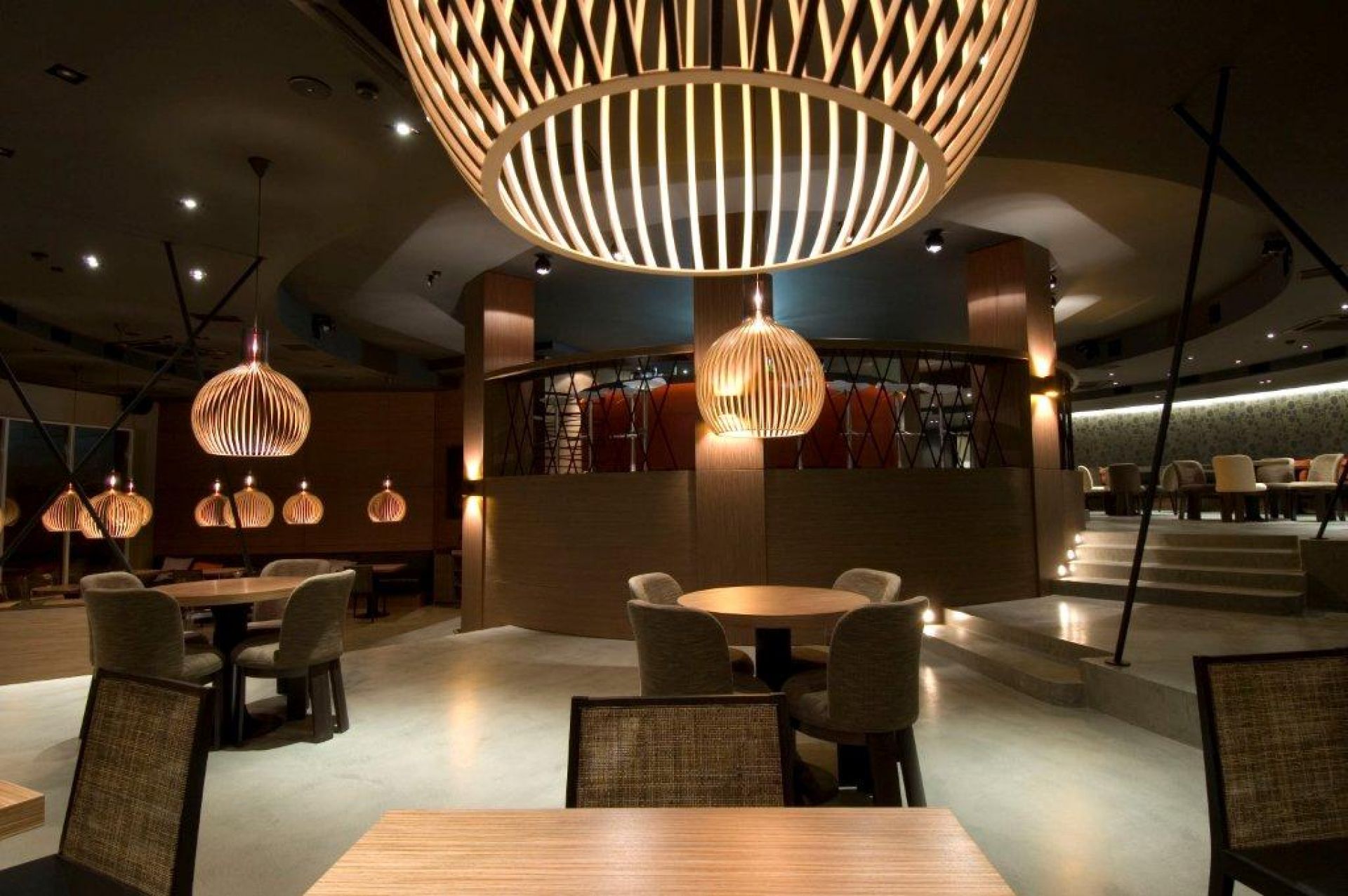 Innenaufnahme eines Restaurants mit mehreren Octo Pendelleuchten von Secto Design aus hellem Holz.