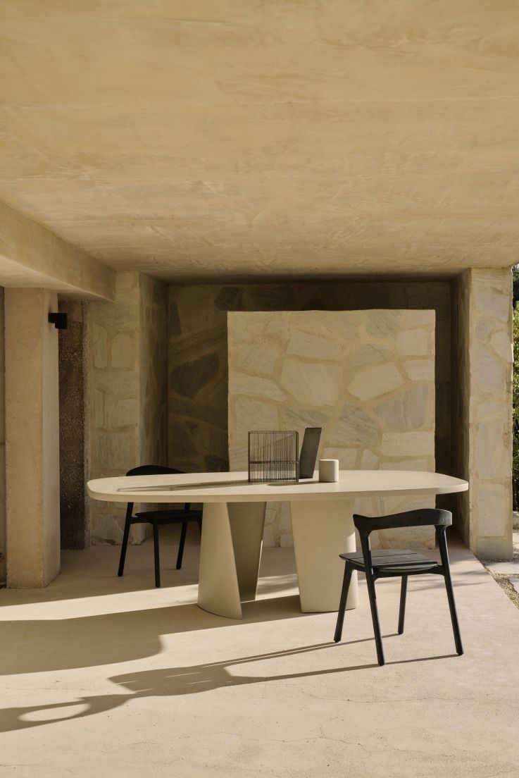 Canyon Esstisch von Ethnicraft, ein moderner Outdoor Tisch aus Beton mit zwei schwarzen Stühlen.