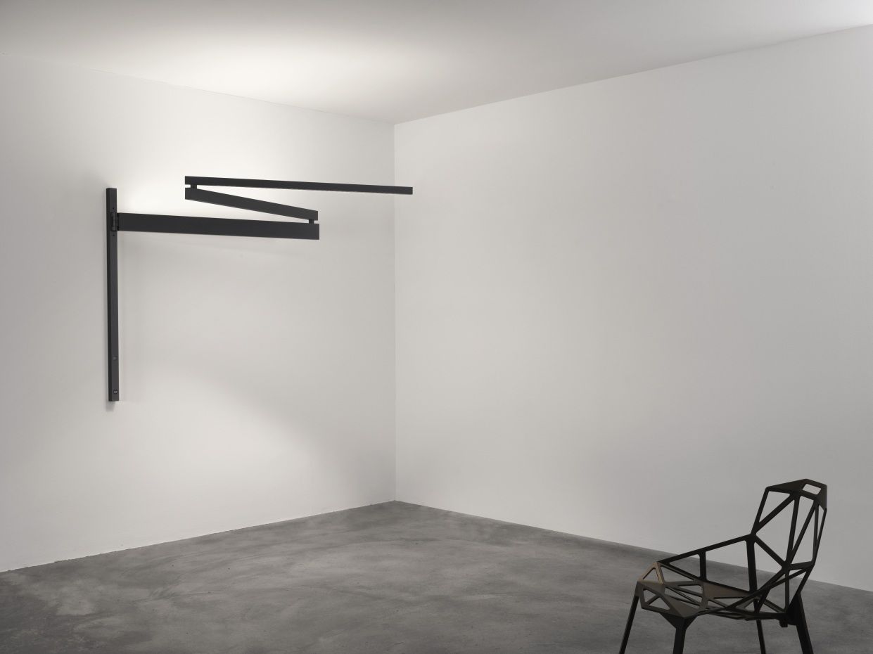 Moderne Black Flag Wandleuchte von Flos, minimalistisches Design mit schwarzem Metallrahmen und warmem Licht.