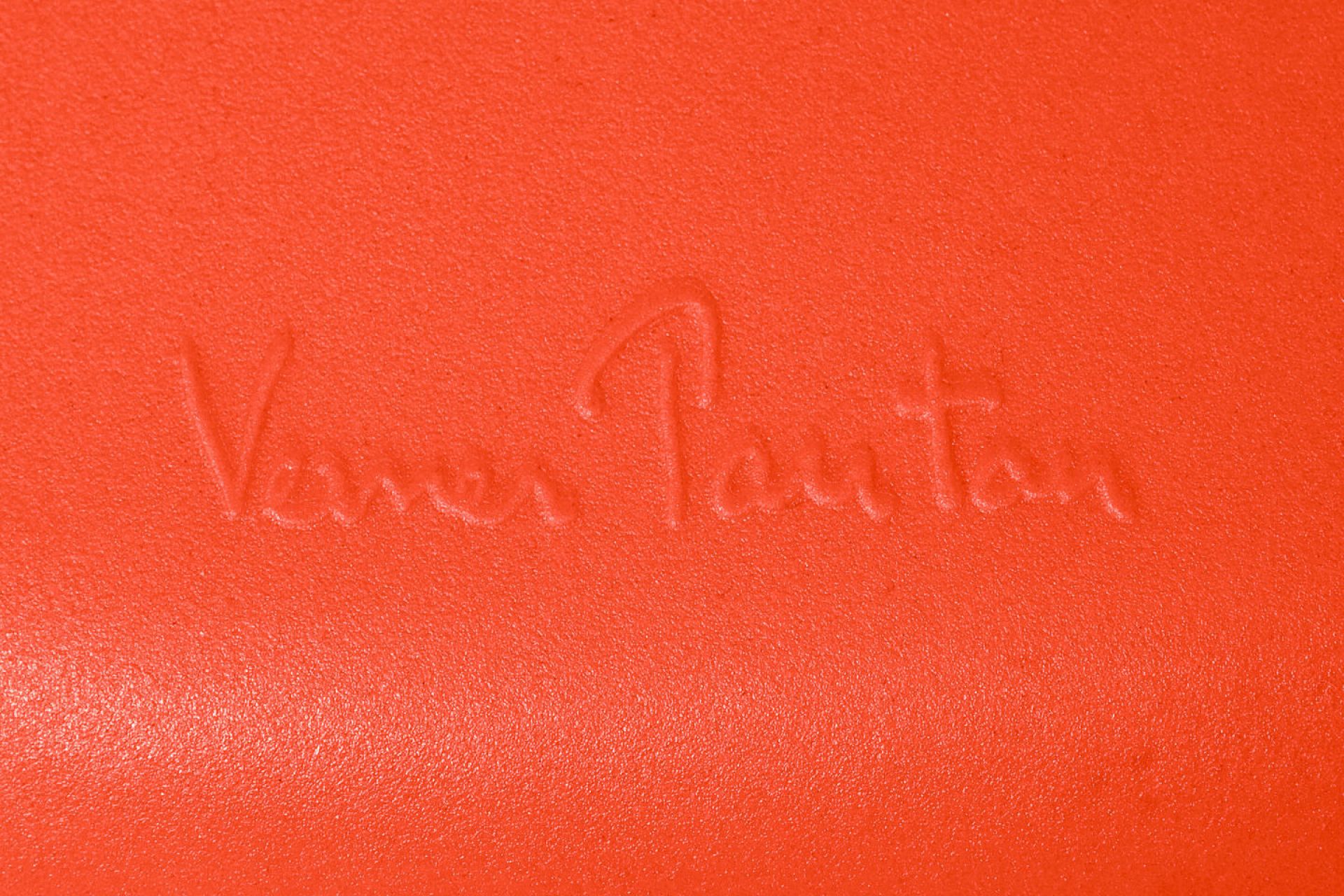 Detailaufnahme der Signatur "Verner Panton" auf einem orangefarbenen Panton Chair Classic Stuhl von Vitra.