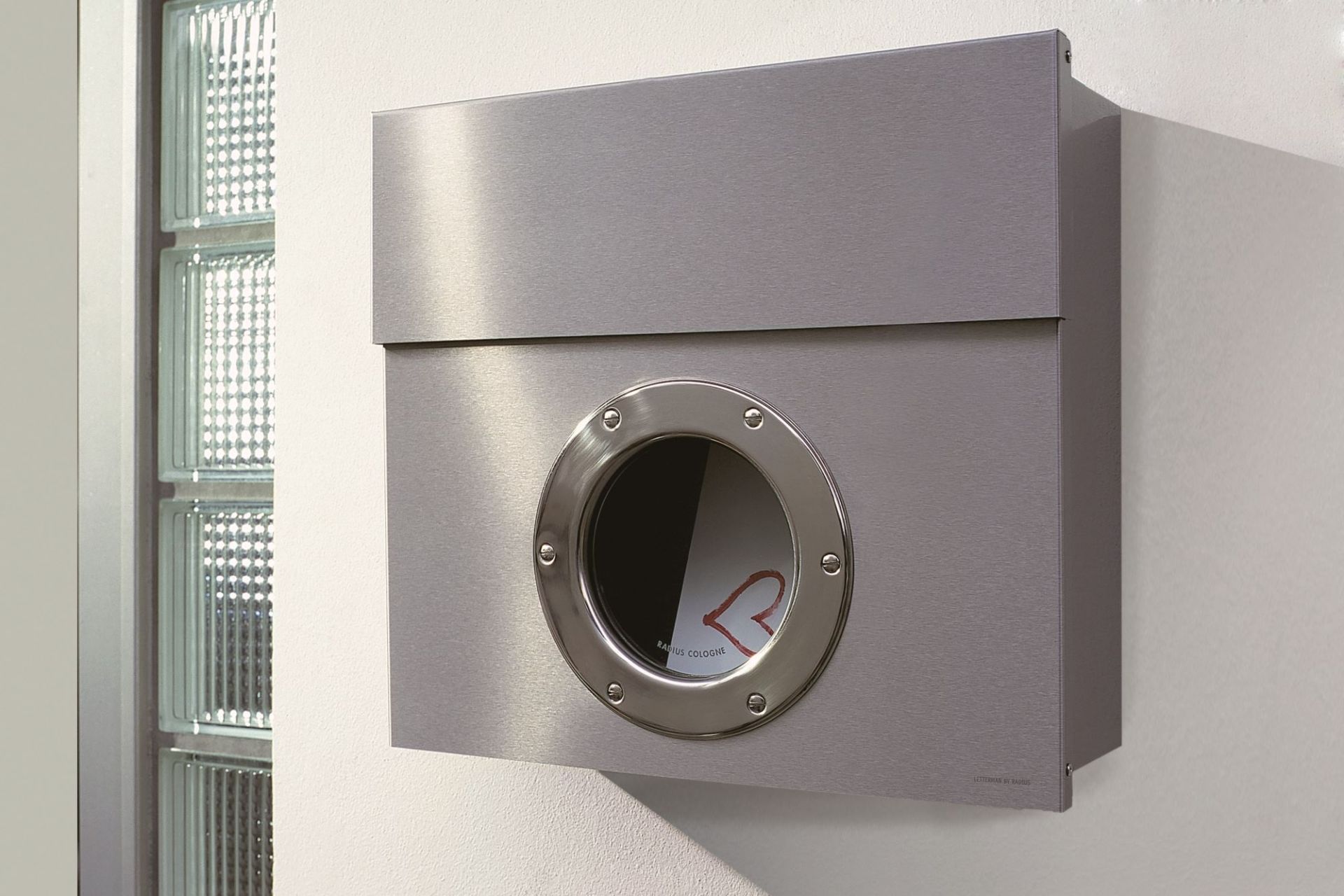 Letterman I Briefkasten Radius aus Edelstahl, moderne Hauspost-Aufbewahrung mit rundem Sichtfenster und Brief im Inneren.