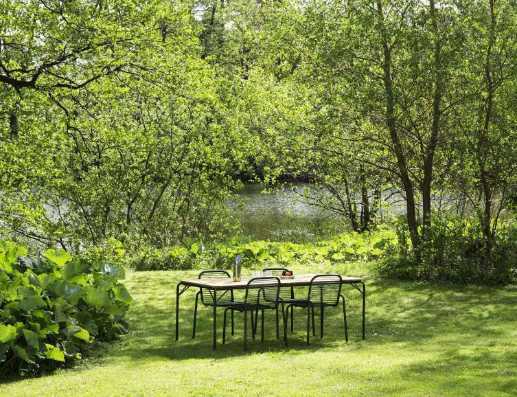 Normann Copenhagen Vig Table Outdoor mit Stühlen im Garten, ideal für entspannte Stunden im Freien.