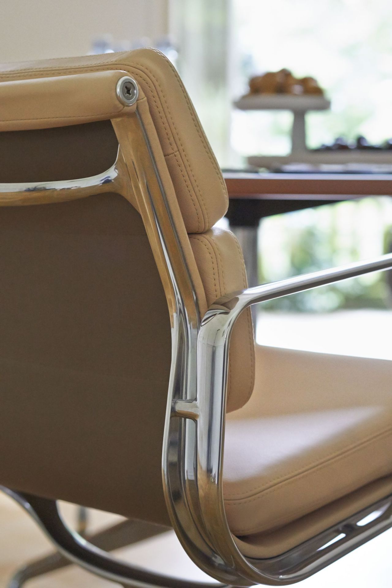 Detailaufnahme: Soft Pad Chair EA 207 Sessel von Vitra mit beigem Leder und Chromgestell.
