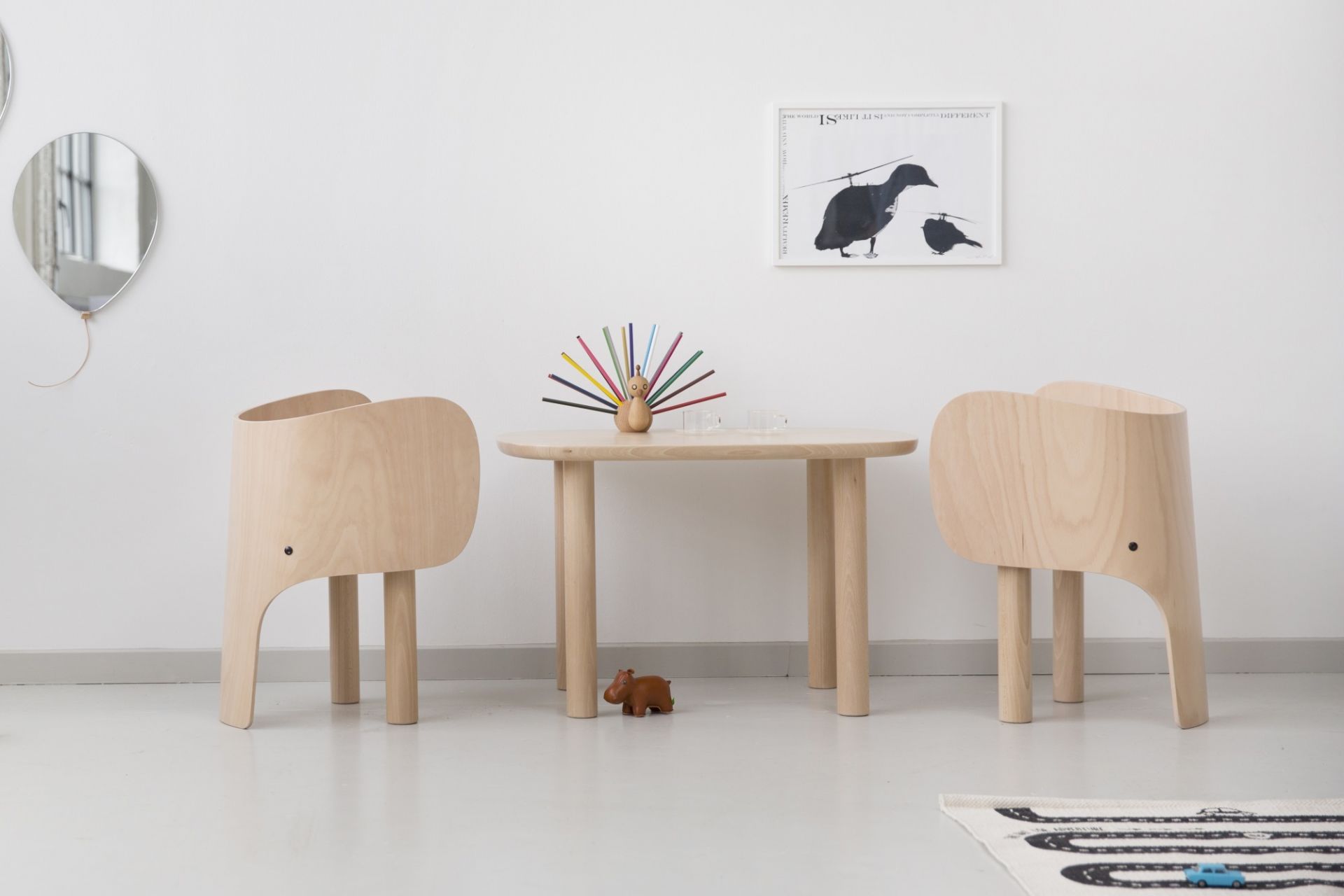 Zwei EO Elephant Chairs Kinderstühle aus Holz und ein passender Tisch in einem Kinderzimmer.