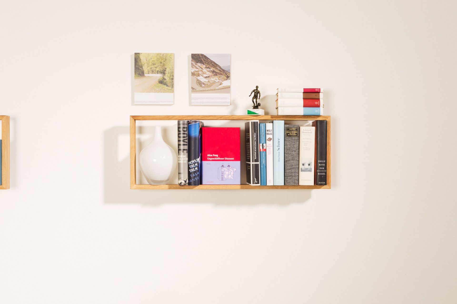 Regal b Eiche, kleines Wandregal aus Eichenholz mit Büchern und Dekoration an weißer Wand.