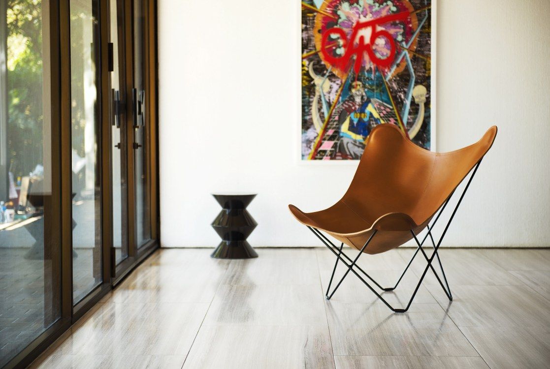 Pampa Mariposa Butterfly Chair Sessel aus braunem Leder mit schwarzem Metallgestell im modernen Wohnraum.