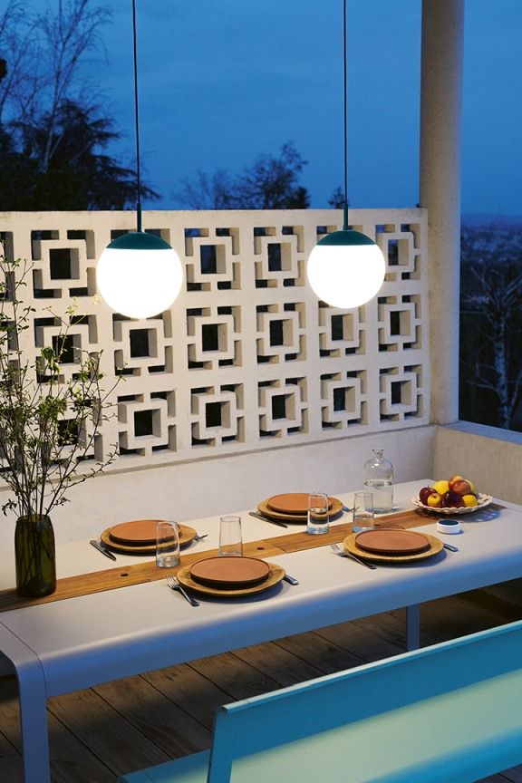 Mooon Pendelleuchte von Fermob über Esstisch. Moderne Außenleuchte für Garten und Terrasse.